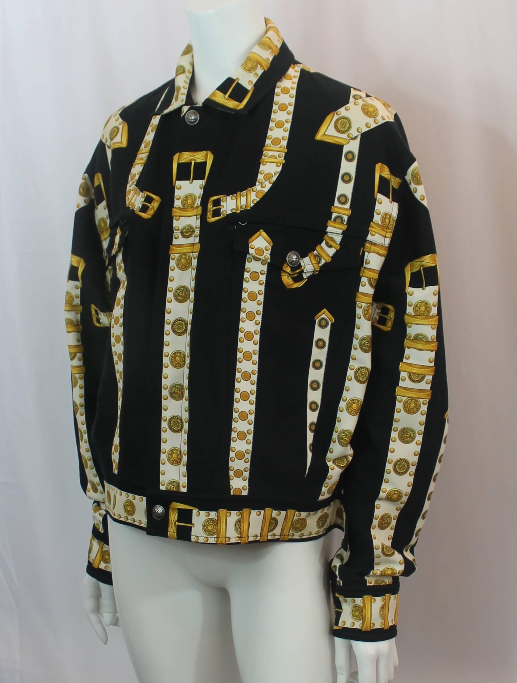 Versace Black, White & Gold Cotton Blend Studded Belt Print Jacket - 48. This 2000's jacket is in excellent condition with light wear consistent with age. The jacket has a jean material with a print that has black in the background and white
