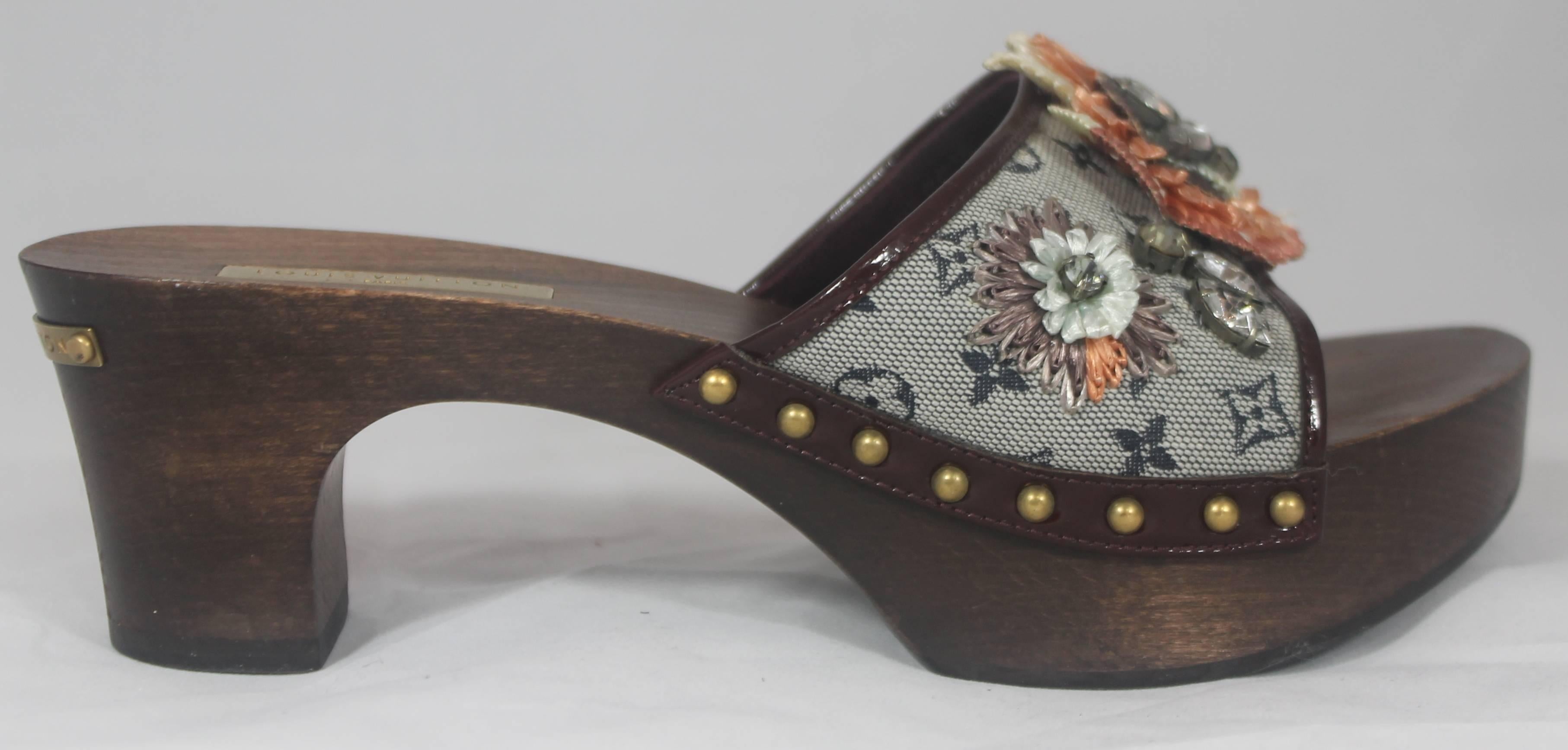Louis Vuitton Grey Monogram Clog w/  Rhinestone and Floral Raffia Decor - 37. These unique clogs have a wooden look to them. On the back of the heel is a gold metal piece that says 