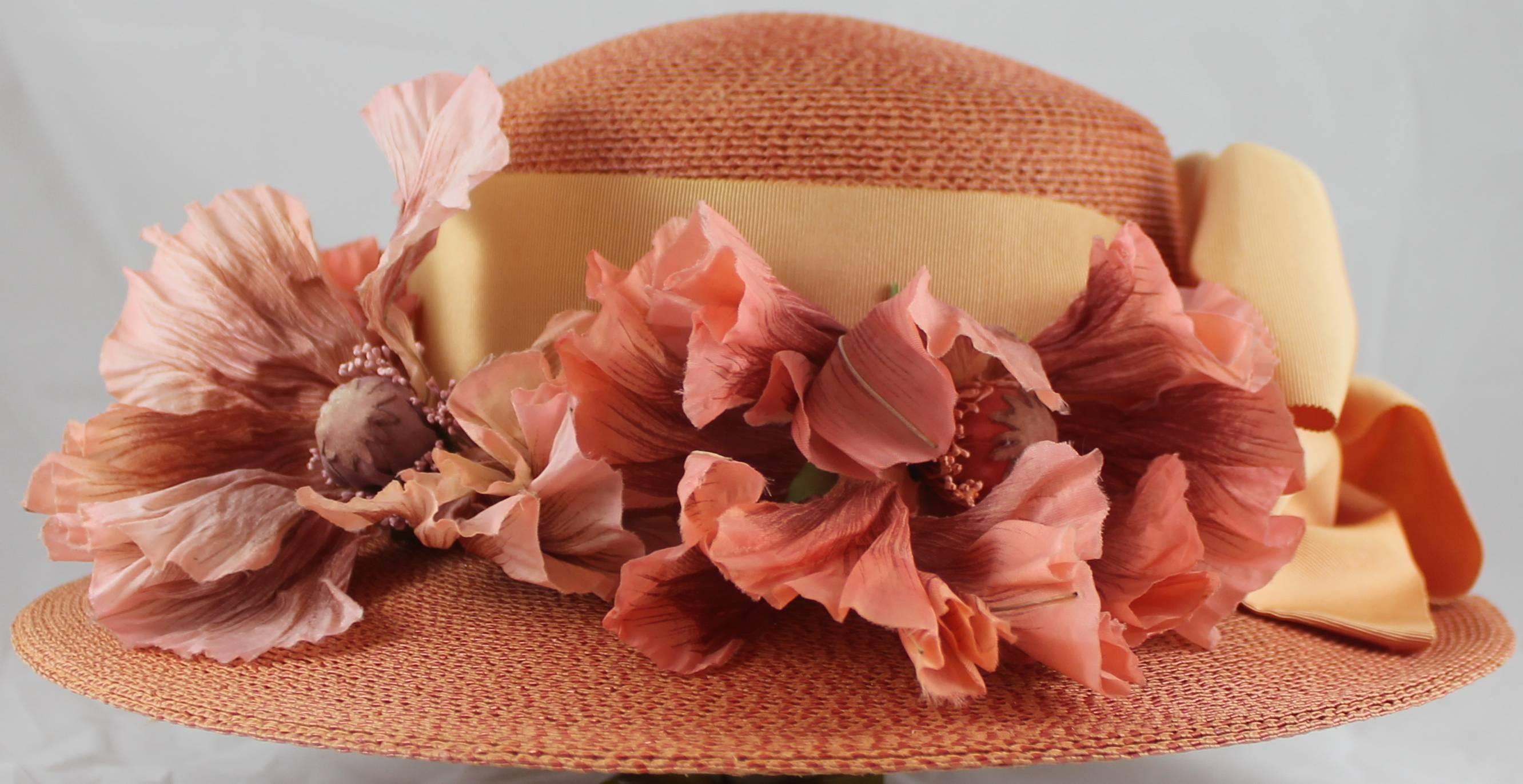 Suzanne Custom Millinery Salmon Round Brim Hat with Large Flowers and Ribbon. This round brim hat is salmon colored and has large pink flowers. There is a melon colored ribbon and a large bow. It is in excellent condition with a very small stain on