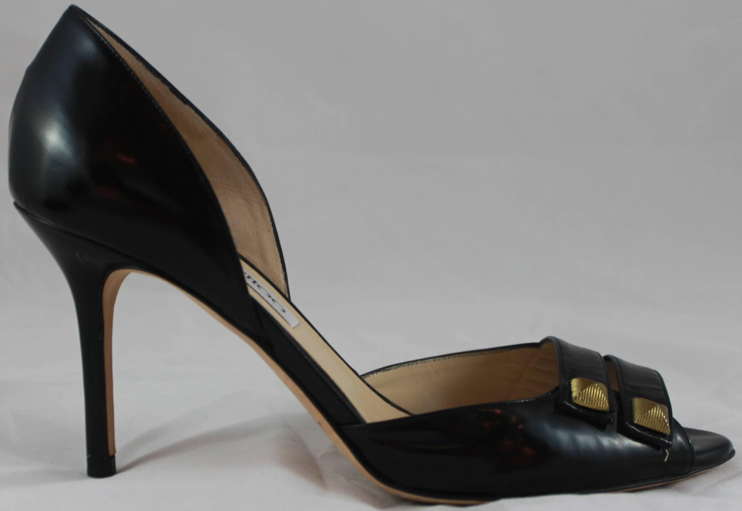 Jimmy Choo Black Leather D'Orsay Heels with Double Straps and Gold Studs - 36.5. These d'orsay heels have an open toe and 2 straps with gold etched studs. A duster comes with them. They are in excellent condition with some bottom wear.
