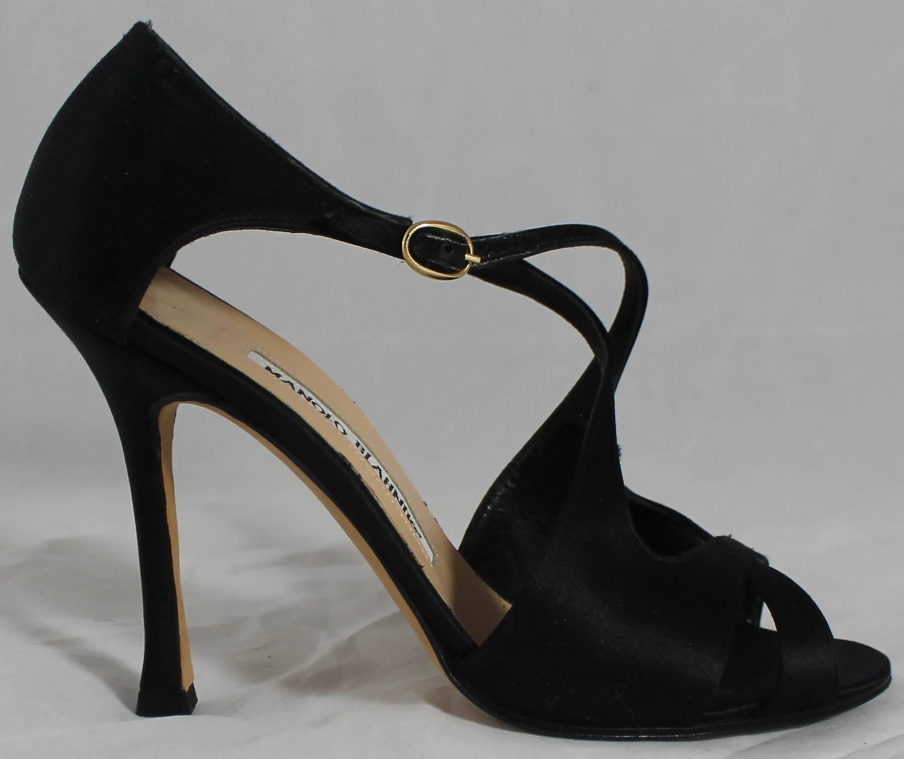 Manolo Blahnik Black Satin Strappy Heels - 36.5. These beautiful heels black satin with criss-crossed straps. On the ankle strap there is a gold closure. They are in very good condition with minor wear on the bottom.

Measurements:
Heel: 4