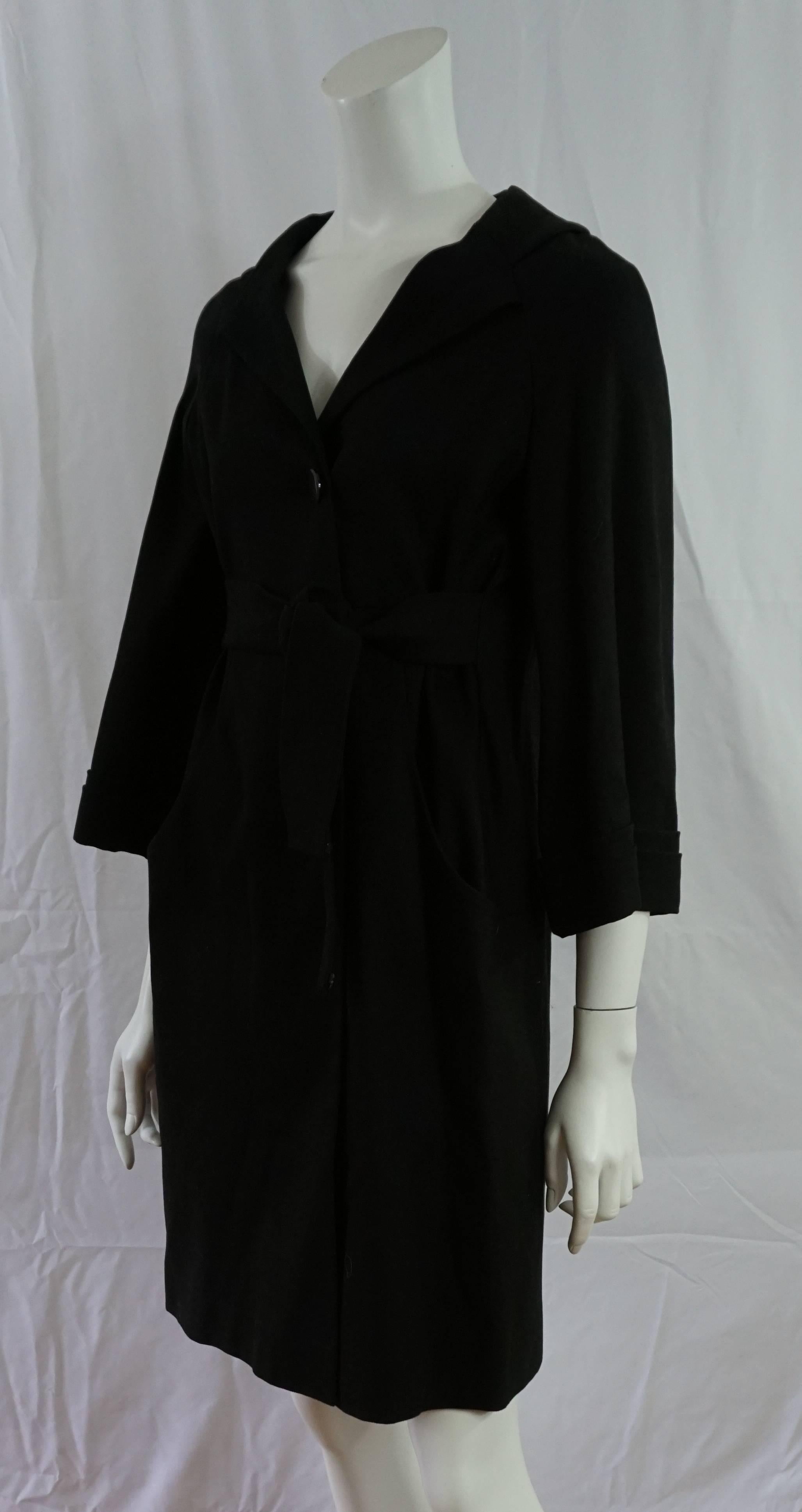 Gucci Black Coat Dress - 42 - NWT  This beautiful coat dress is made of a Hemp blend, has a 3/4 sleeve, ties at the waist and has 3 Gucci Logo buttons. The sleeves have a cuff, 2 pockets. NWT. 
Measurements:
Bust 35"
Shoulder to Shoulder