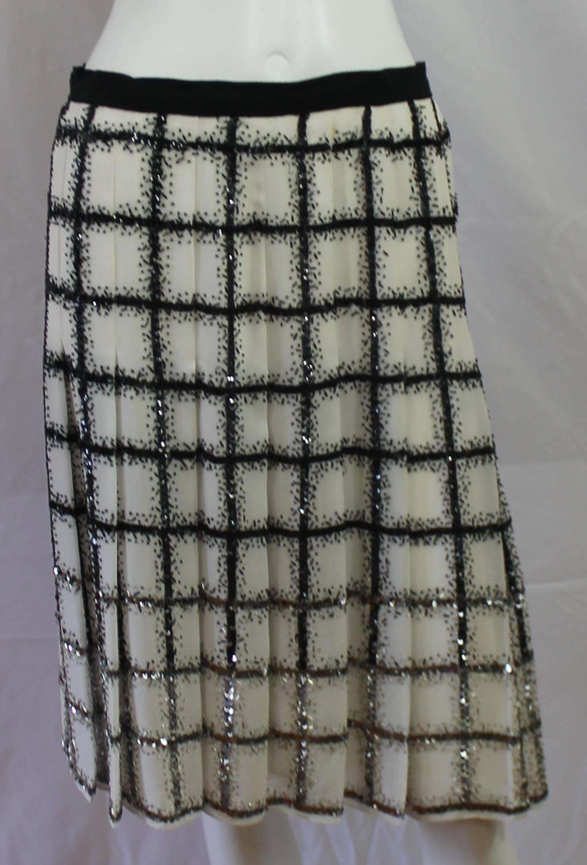 Oscar de la Renta Ivory & Black silk chiffon window pane black and silver beaded/sequin pleated skirt - 4 This amazing skirt has a black grosgrain ribbon at waistline w/ a zipper at center back. The skirt is fitted to the hip (aprox 8 inches from
