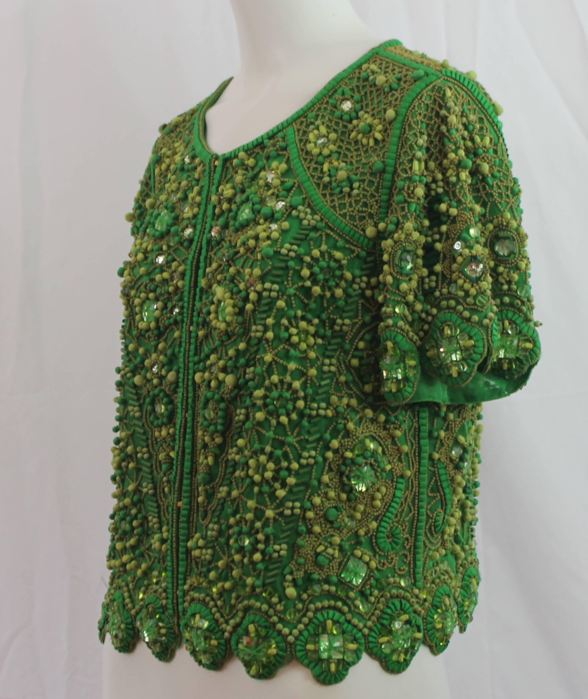 Escada Green Silk Heavily Beaded Jacket/Top - 36 This beautiful and very unique top/jacket has short sleeves and is heavily beaded throughout the entire garment with green and tan beads of different sizes and textures. The front has hidden hook and