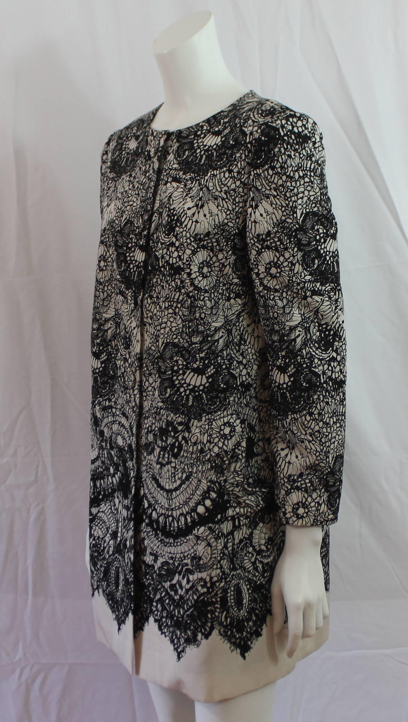 Prada Black & White Lace Printed Silk Taffeta Coat - 42. This coat is a twist on a classic look and features snap buttons and bow detail pockets. It is in excellent condition.

Measurements:
Bust- 40