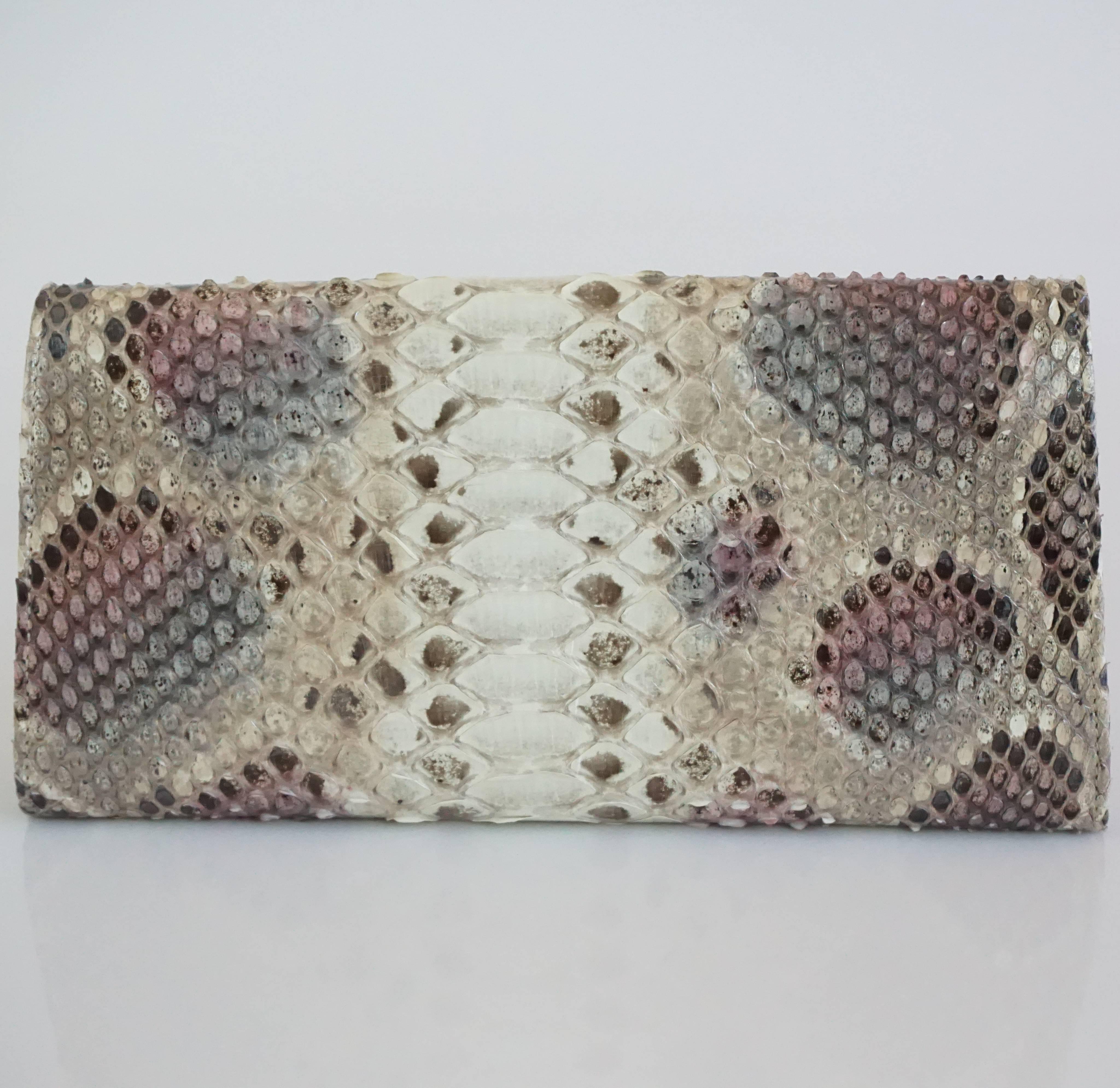 Jimmy Choo Earthtone Python Clutch with Strap - GHW. This clutch is an elegant piece which features a light gold closure with the Jimmy Choo logo, a leather and grosgrain interior, 8 card slots, 1 large zipper compartment, and a strap with chain