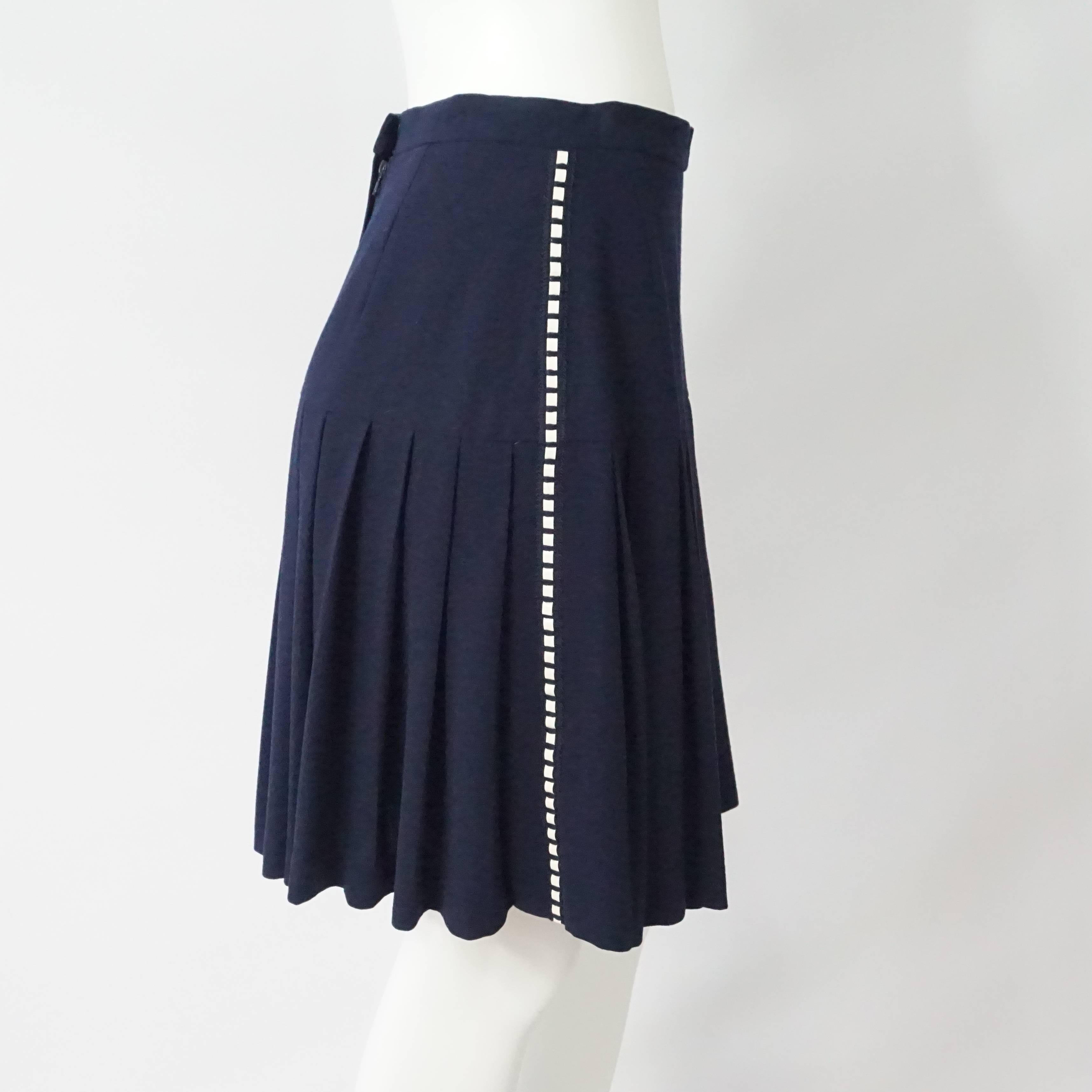 Chanel Navy Wool Pleated Skirt w/ white patent detail - 40 - Circa 80's This short navy wool skirt is fitted to the hips and then has pleats, along each side there is a threaded patent stripe detail, back zip and it is in excellent vintage