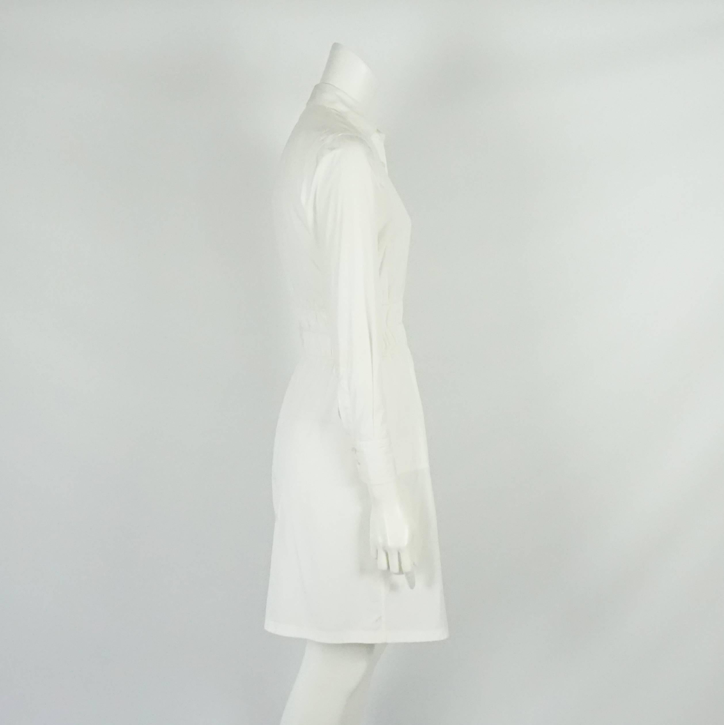 Bottega Veneta White Cotton Long Sleeve Dress with Cinched Waist - 40. This shirt dress is perfect for traveling and warm weather. It is a great staple to add to your wardrobe. It features stitched waist cinching that is expandable and buttons all