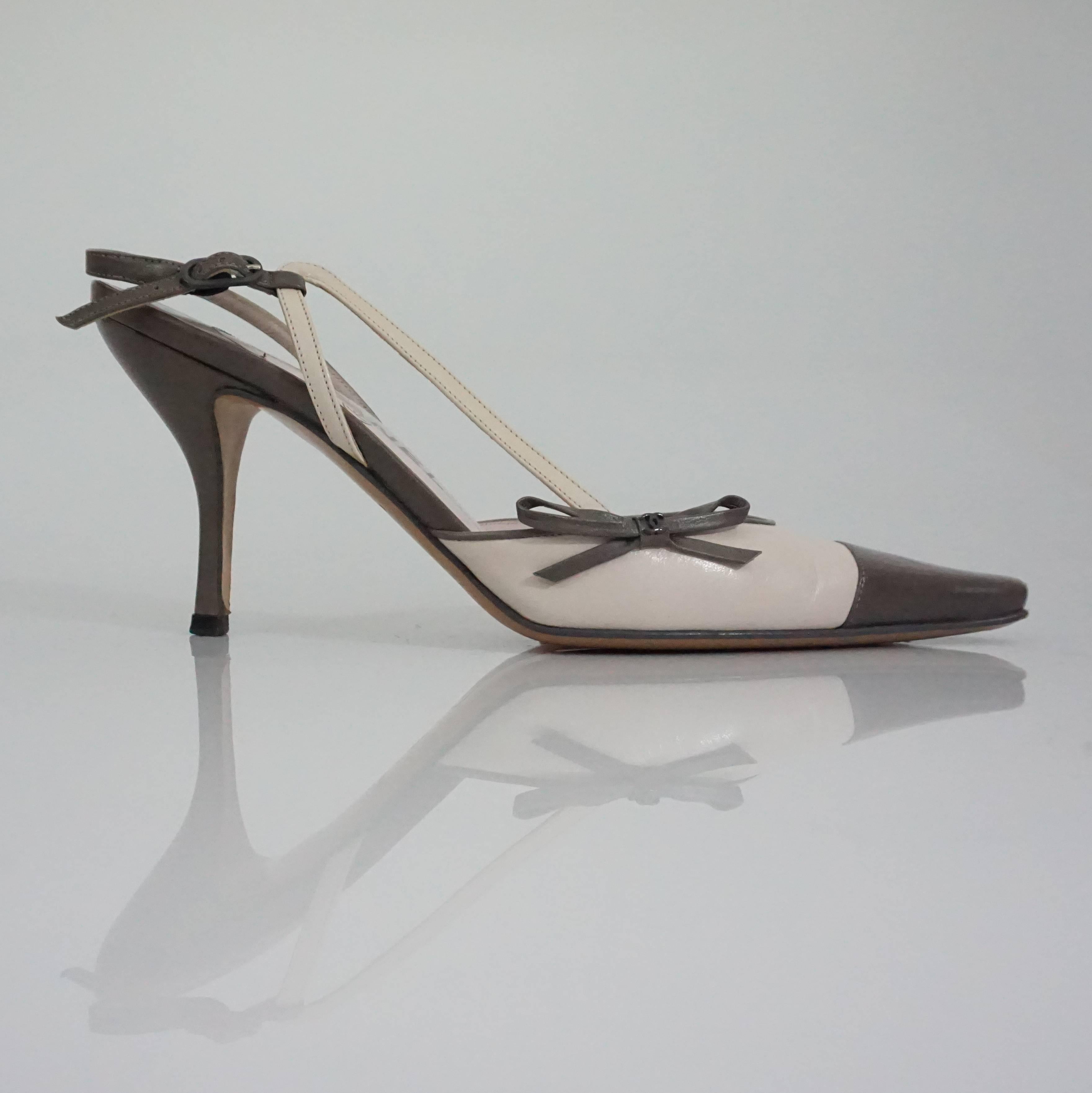 Chanel Creme and Taupe Slingback Heels - 37.5 These slingbacks have a side bow with an extra decorative strap coming up one side of the shoes. The shoe is in good condition, with minor wear. 
Measurments:
Heel height: 3.75