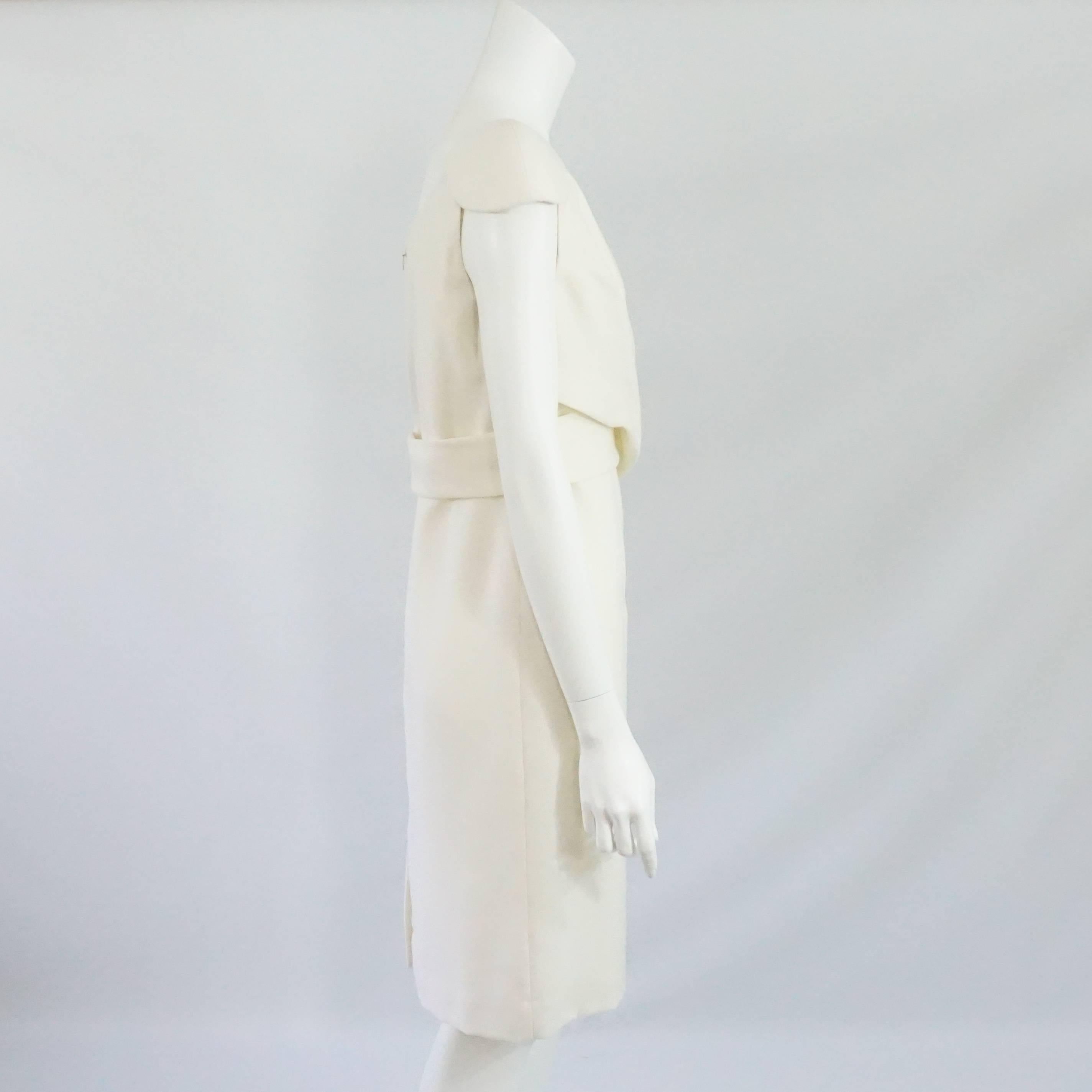 Alexander McQueen Ivory Wool Dress with Crossed Front Design - 46. This dress is a classic must have. It features a padded cap sleeve, V-neck, back zipper, back center slit, and crossing fabric in the bust to waist area. It is in excellent condition