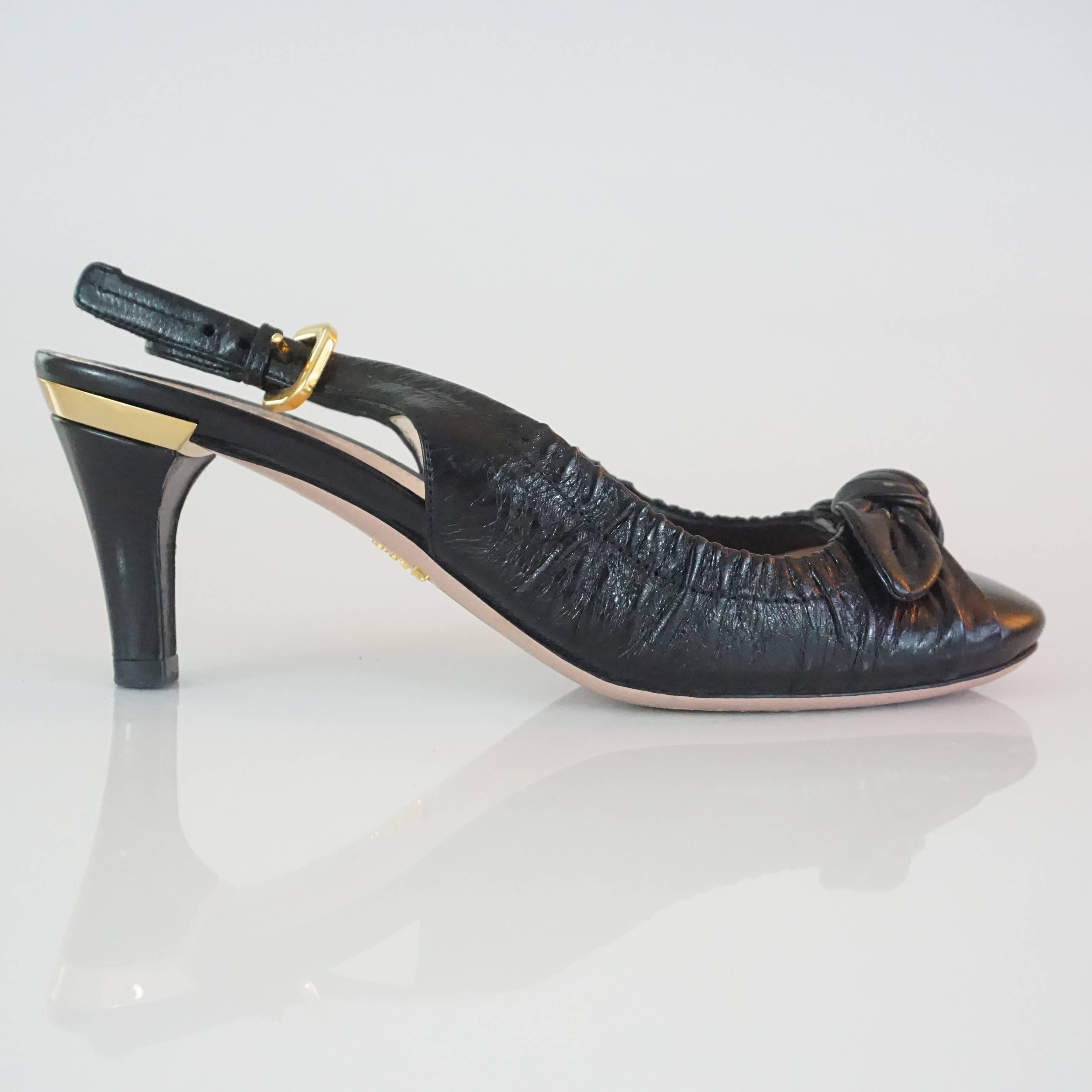 Prada Black Leather Ruched Slingback Heels - 36.5. These heels have a classic look. They a ruched all over with a front tie and have a gold plaque with the Prada logo at the top of each heel. They are in very good condition with some bottom wear and