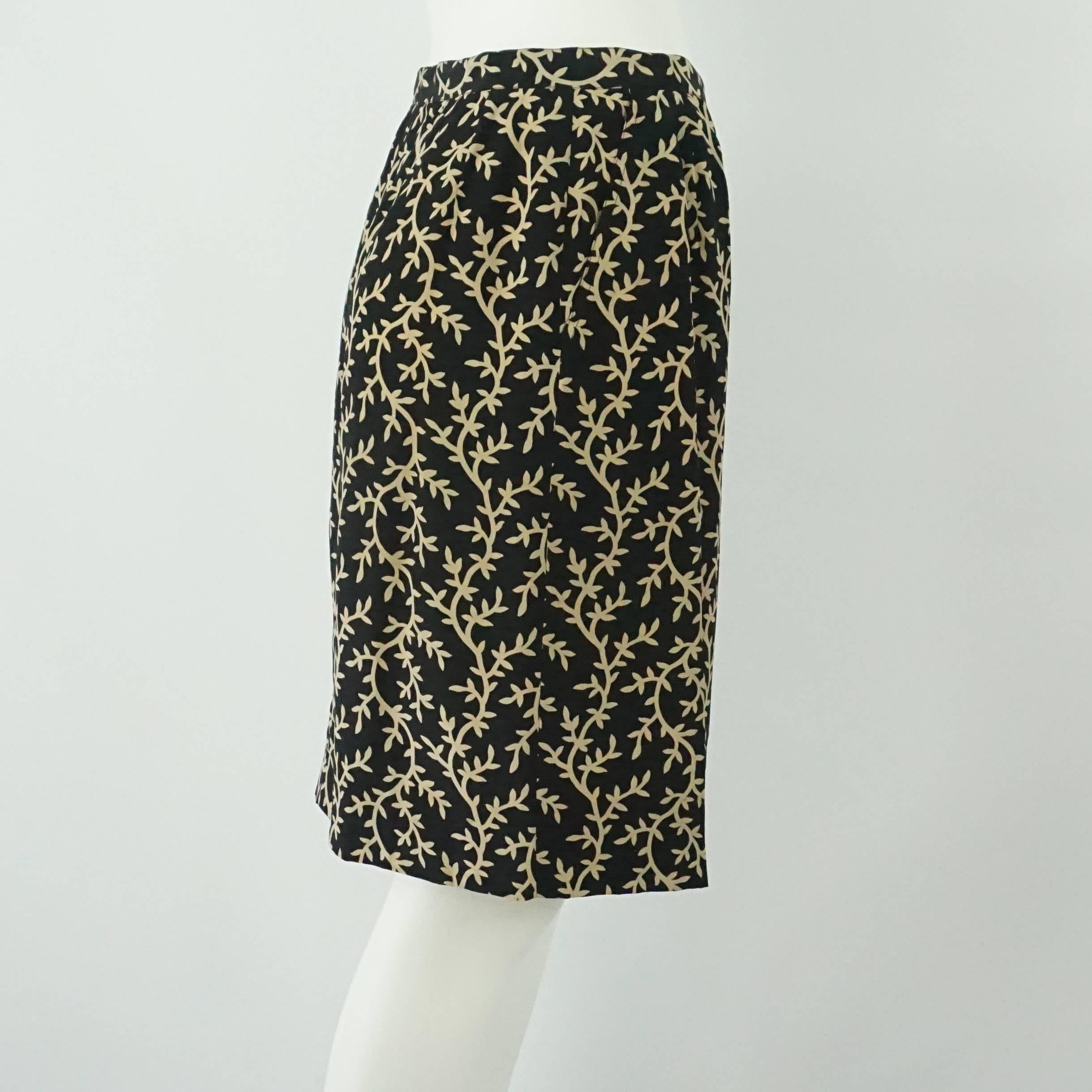 Chanel Black and Tan Skirt - M. This Chanel skirt is black with a tan branching design. It has a gold button and a straight skirt style. This skirt is in excellent condition. Size M.
Measurements
Waist: 28