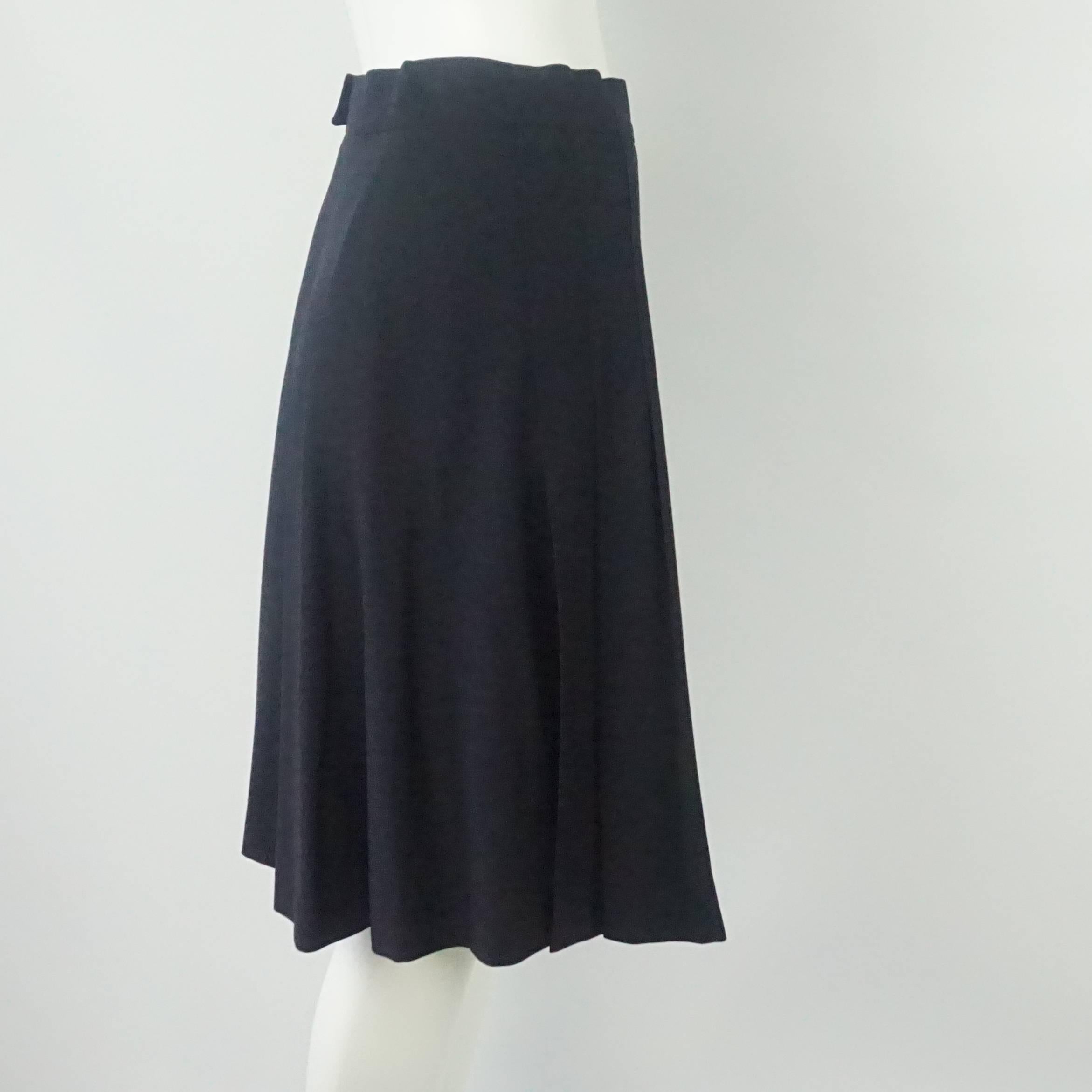 This Chanel skirt is navy with front pleats. It has a flowing structure. This skirt is in excellent condition. Size 38.

Measurements
Waist: 28.5