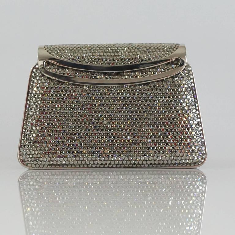 Judith Leiber Silver Crystal Minaudiere - Circa 90's  This beautiful and classic Leiber piece is a must have for any collector. The bag can be used as a clutch or with the hanging chain as a shoulder bag. With the hanging chain this bag can be worn