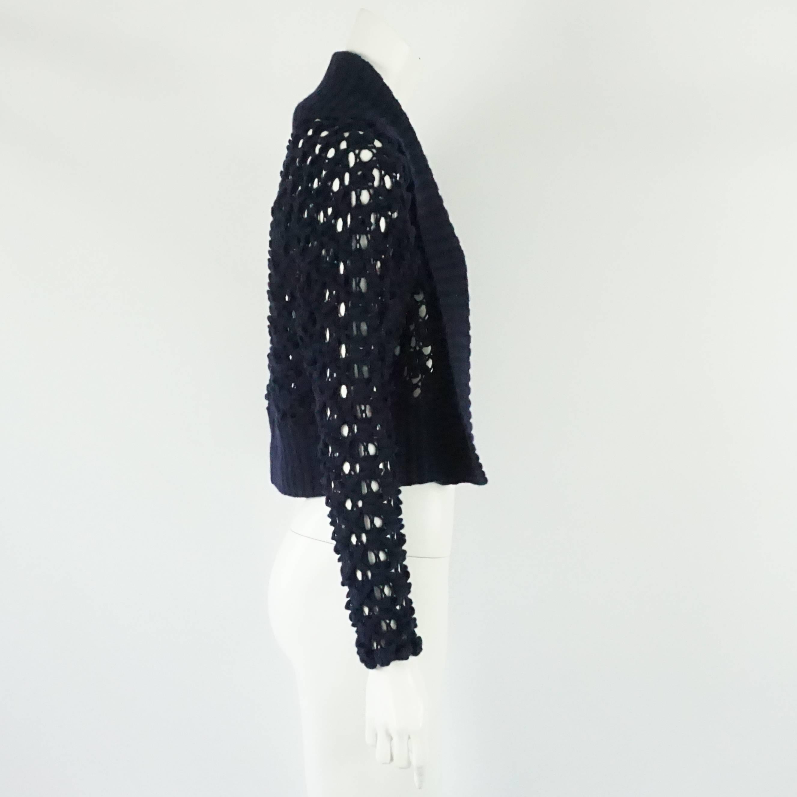 Oscar de la Renta Navy Crochet Cashmere Cardigan - XS  This crochet style cashmere sweater/cardigan has a ribbed collar and border along the bottom of the sweater. This piece is in excellent condition.
Measurements:
Collar width: 6