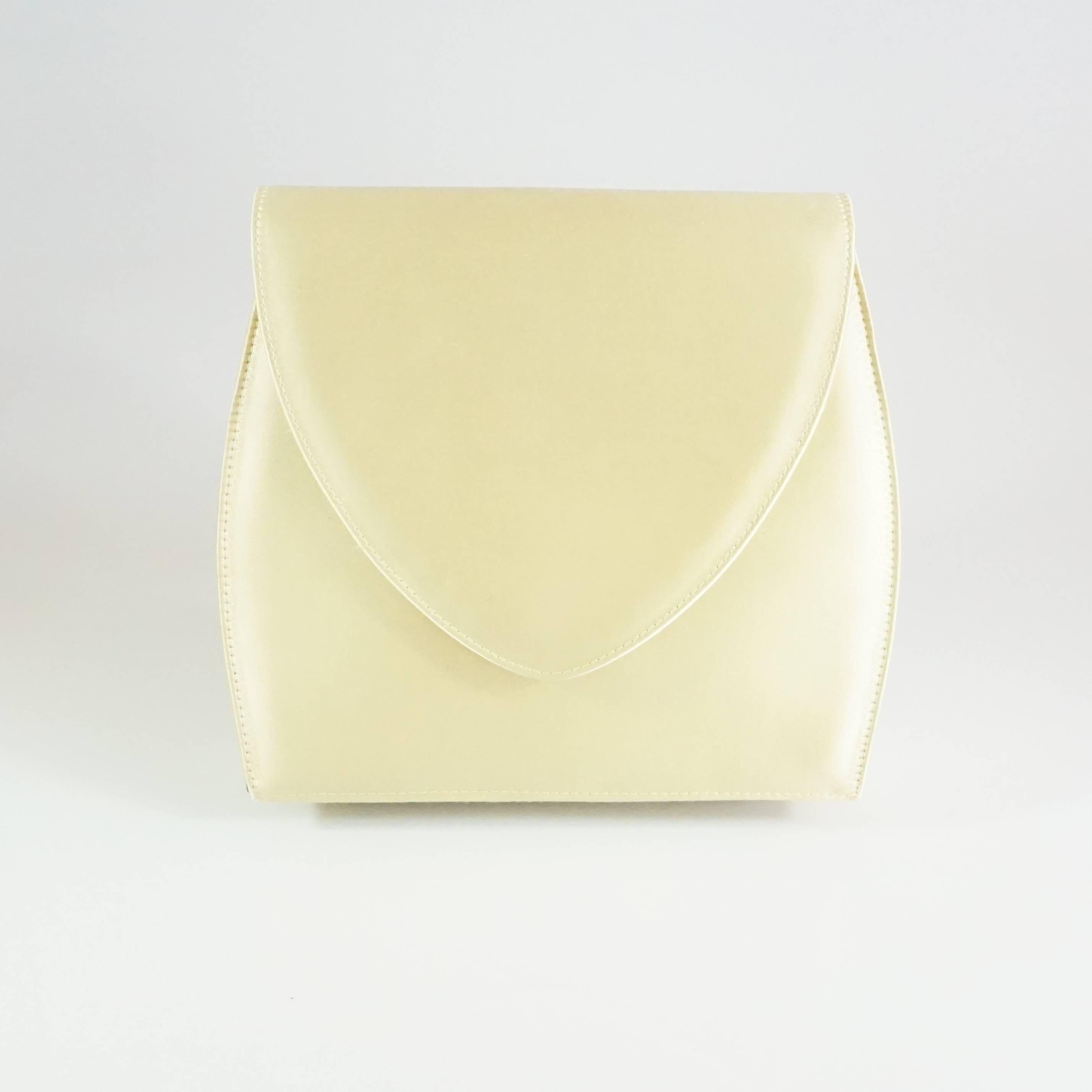 Charles Jourdan Pale Yellow Satin Crossbody and Clutch. This bag has a vintage feel brought to the modern day. It has a structured design with a black interior and a long strap. It is in good condition with light wear. 