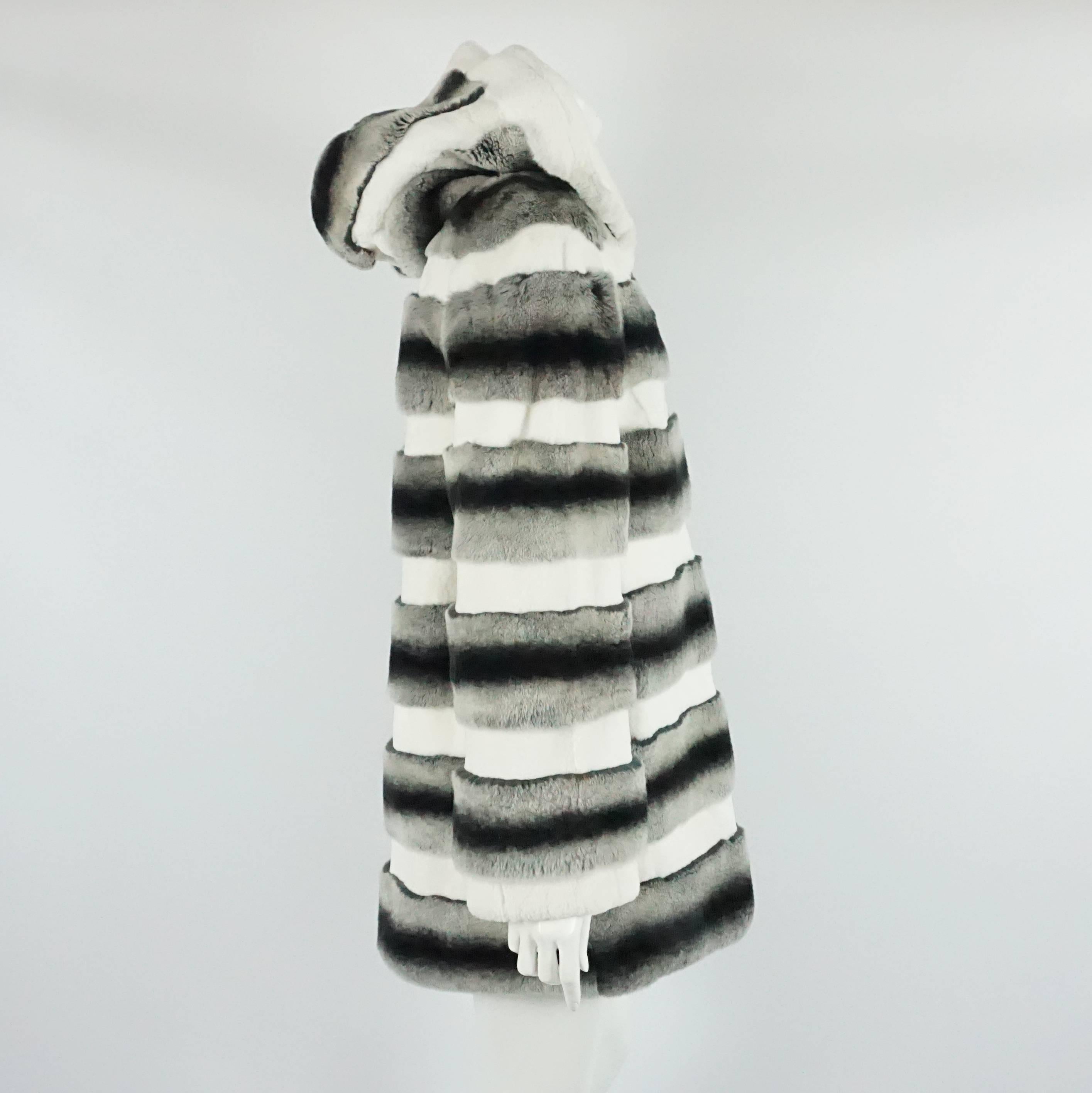 White, Gray, and Black Striped Rabbit 3/4 Coat - M. This coat is in excellent condition with light wear to the fur. It has a loose style and features a hood, large mother of pearl button, 2 front pockets, and vertical hook and eye