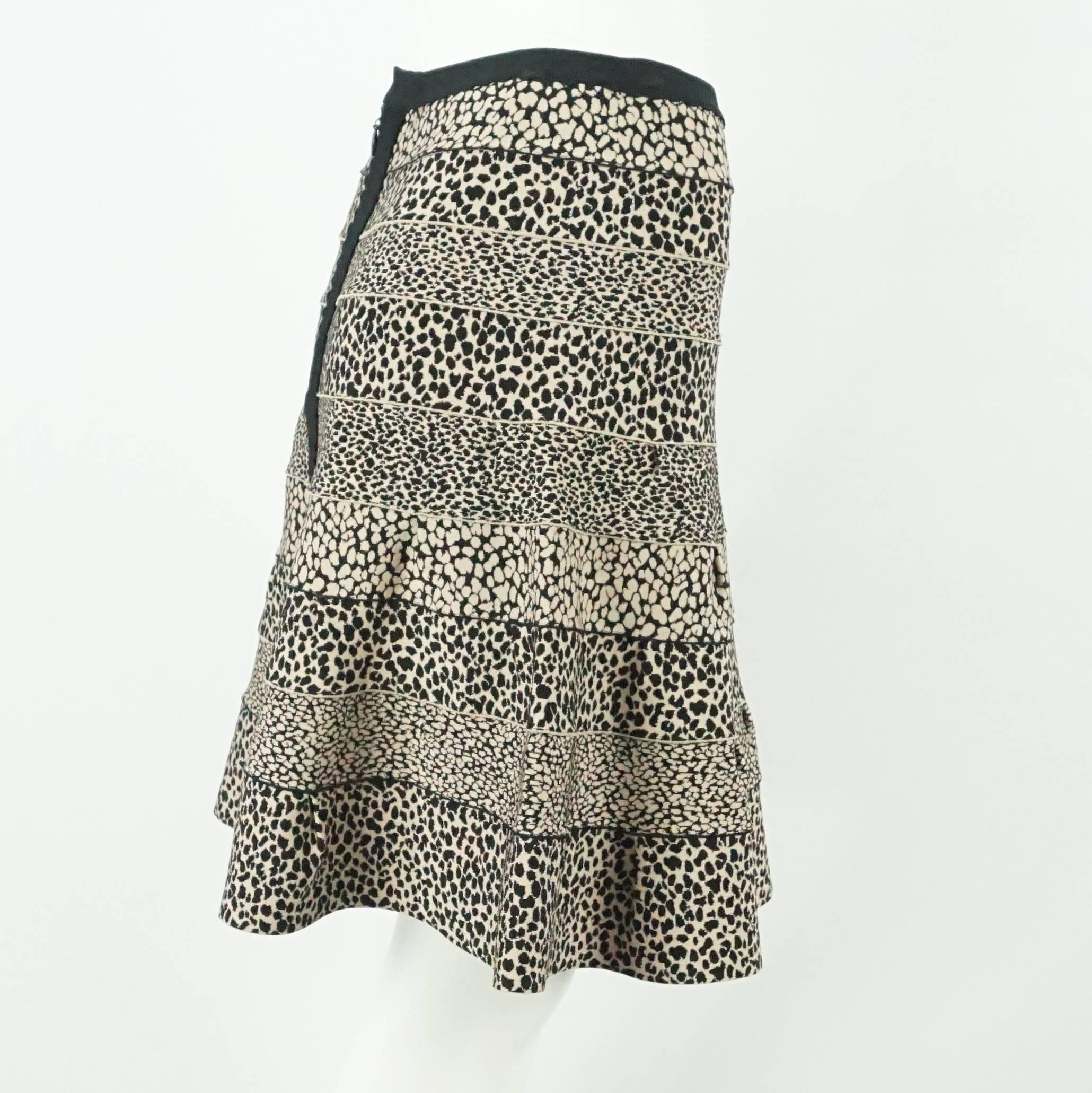 This Herve Leger A-line skirt features a black and tan animal print with a black trim and stripe going down the back where the zipper is. It is made of a rayon-blend bandage material. This skirt is in excellent condition.

Measurements
Waist: