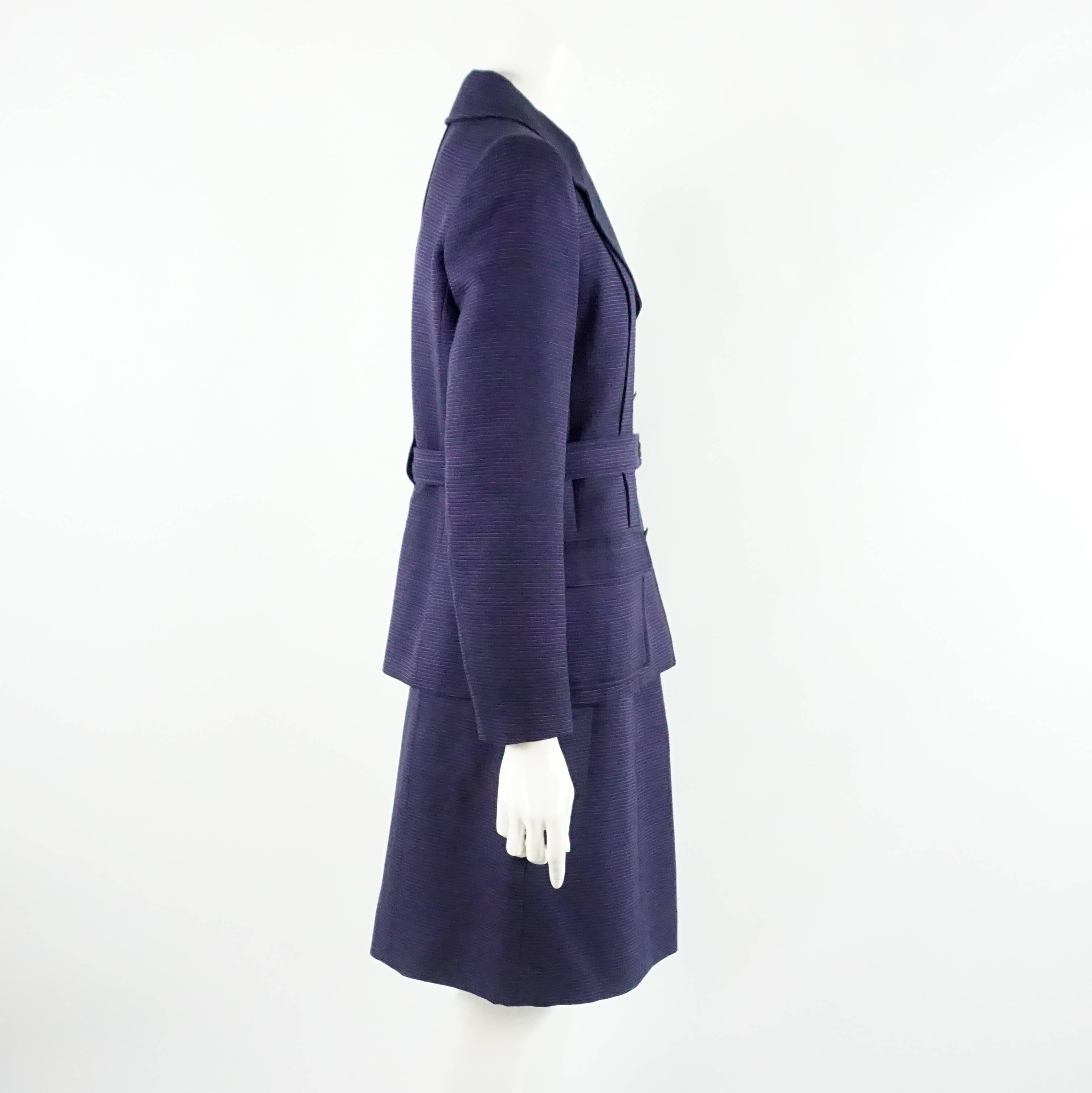 Chanel Purple Two Toned Wool/Silk Blend Ribbed Skirt Suit - Size 40. This vintage skirt suit is a made of a deep purple wool fabric that has a thin lighter purple horizontal pinstripe detail. The fully silk lined jacket has a fitted style with a 2