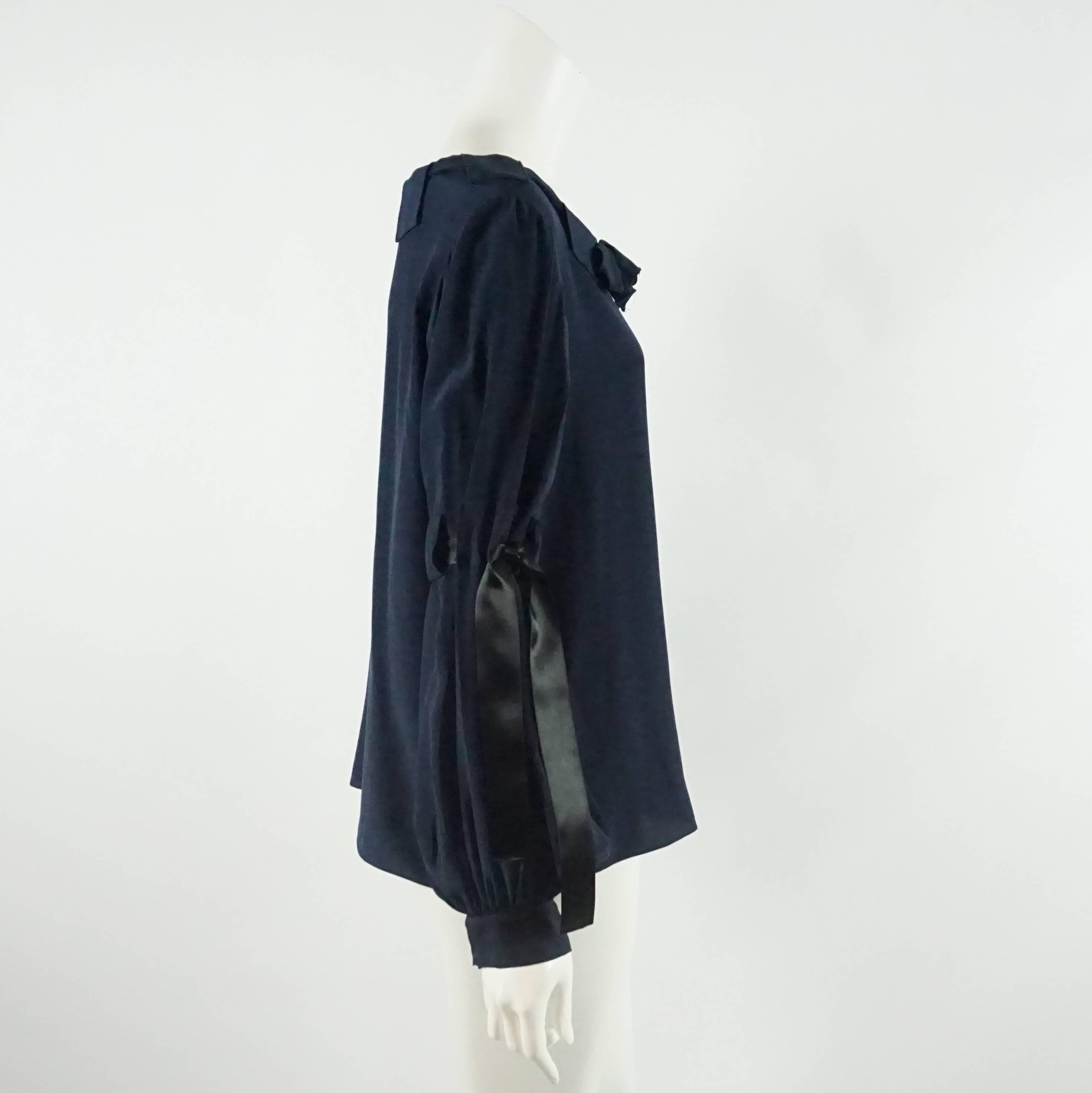Oscar de la Renta Navy Silk Long Sleeve Top with Ties - L. This top is gorgeous with a chic style. It features a puffed sleeve with black ribbon ties. The top is in very good condition with light wear consistent with use.

Measurements
Bust: