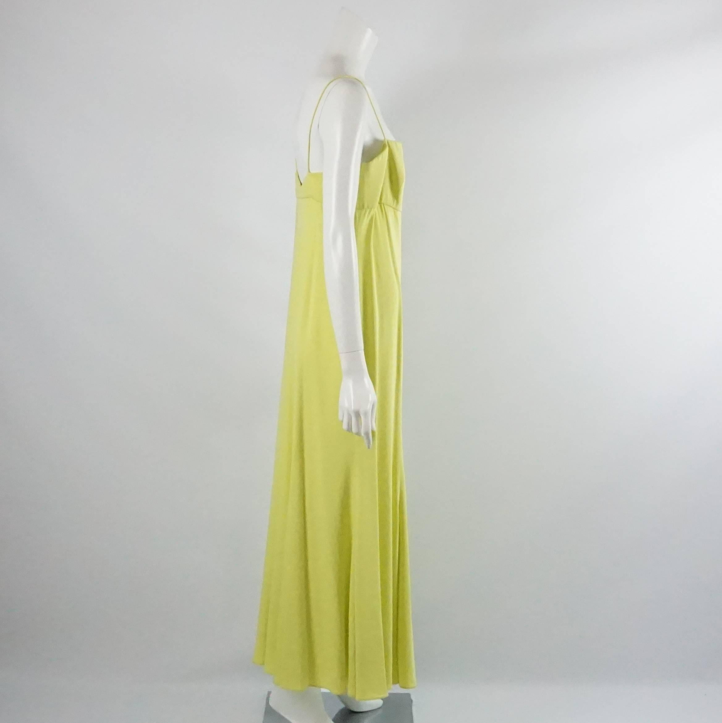 This Giorgio Armani gown is chartreuse silk. It has spaghetti straps and pleating on the bottom. This gown is in fair condition with some staining and runs in the fabric. Size 46. 

Measurements
Bust: 35