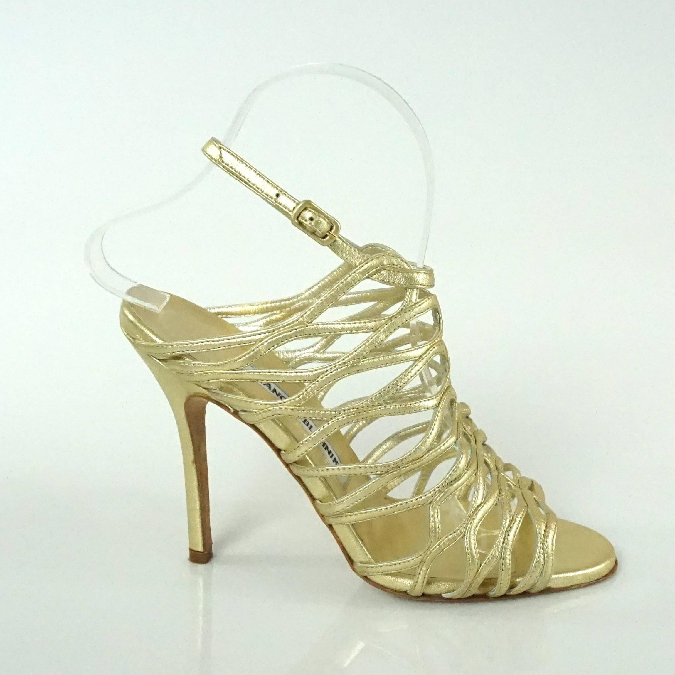 Manolo Blahnik Gold Leather Caged Heels - 37. These heels are new and have never been worn; they come with a duster and the box. They have a cutout, caged look with an ankle strap and are truly gorgeous.

Heel Height: 4.25