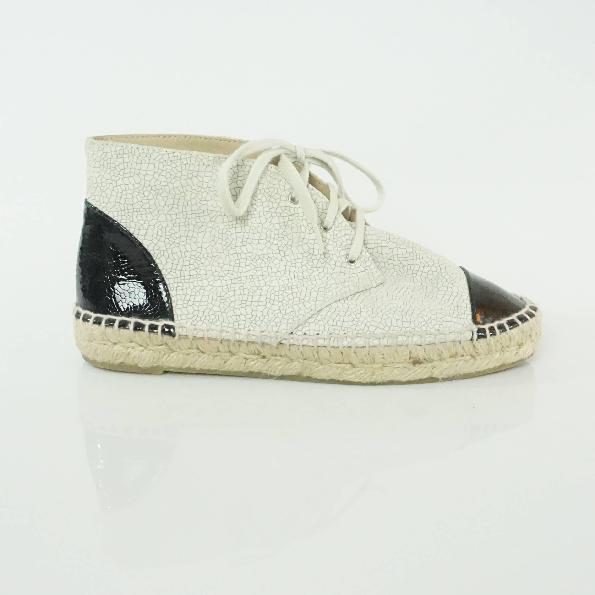 Chanel Beige and Black Cracked Patent High Top Espadrille Sneakers - 38. These shoes are in excellent condition with very light wear. Both the beige regular leather and the patent are cracked and the sneakers are a lace-up style. 

