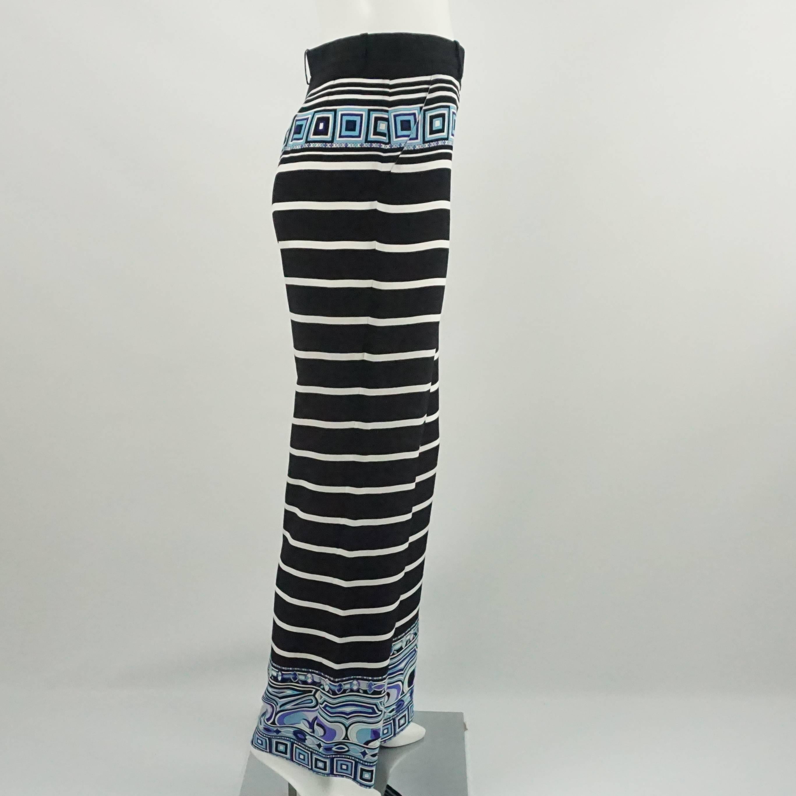 These Emilio Pucci silk palazzo pants are black with white stripes and blue pattern detailing at the waist and at the bottom of the legs. There are belt loops and a zipper. They are in excellent condition. 

Measurement
Waist: 28.5