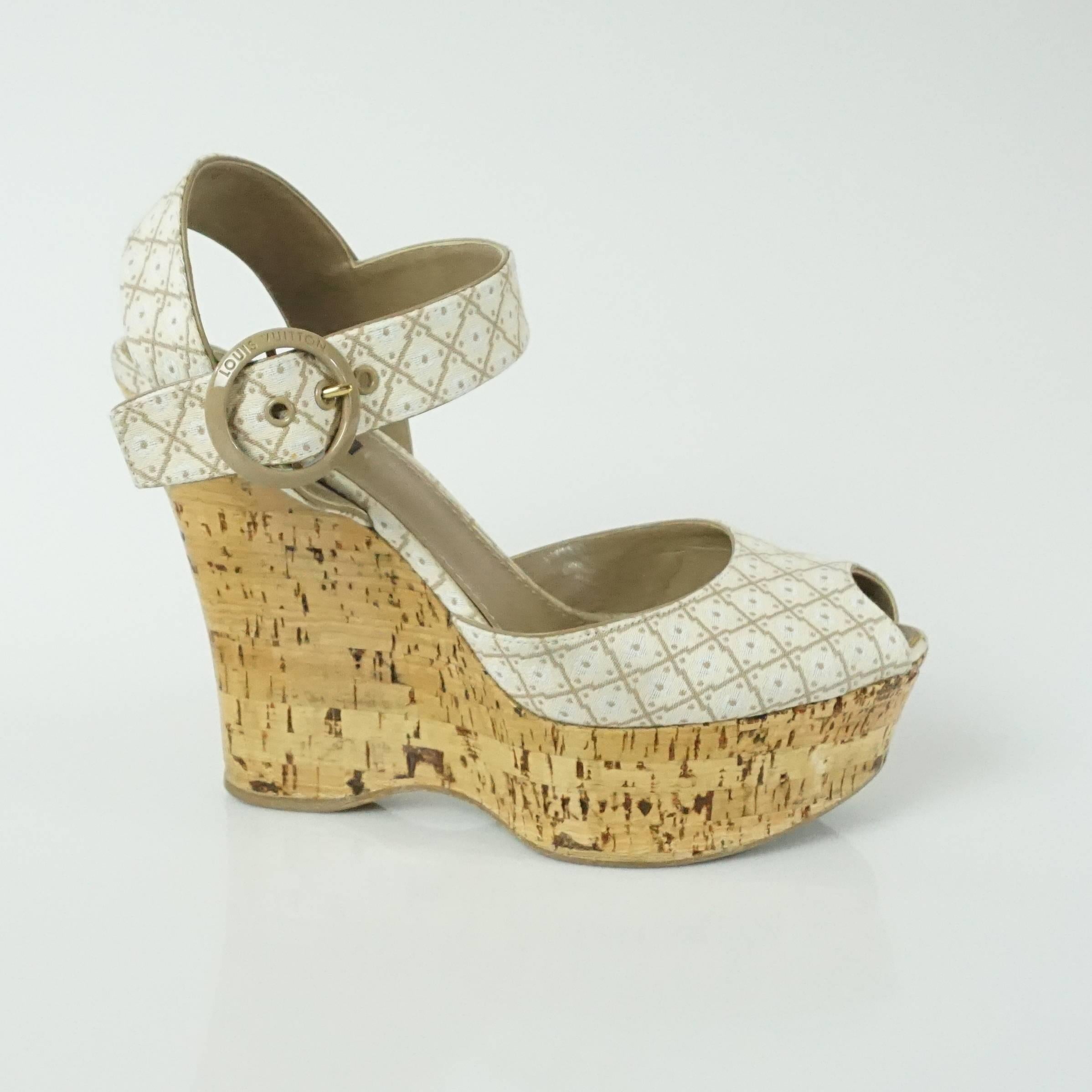 This Louis Vuitton cork wedges feature a strap on the upper part of the foot, a peep toe, and an ankle strap. They have a beige circular closure on the ankle strap with the words 