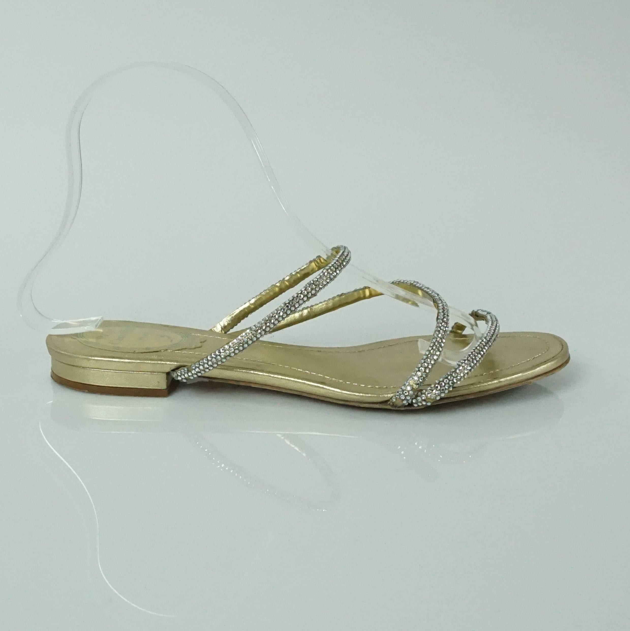 These flat sandals are strappy, They are gold and have 3 straps on them covered in rhinestones. They are in good condition with minor wear on the bottom and some missing stones (see pictures).

Measurements
Heel: 0.5"