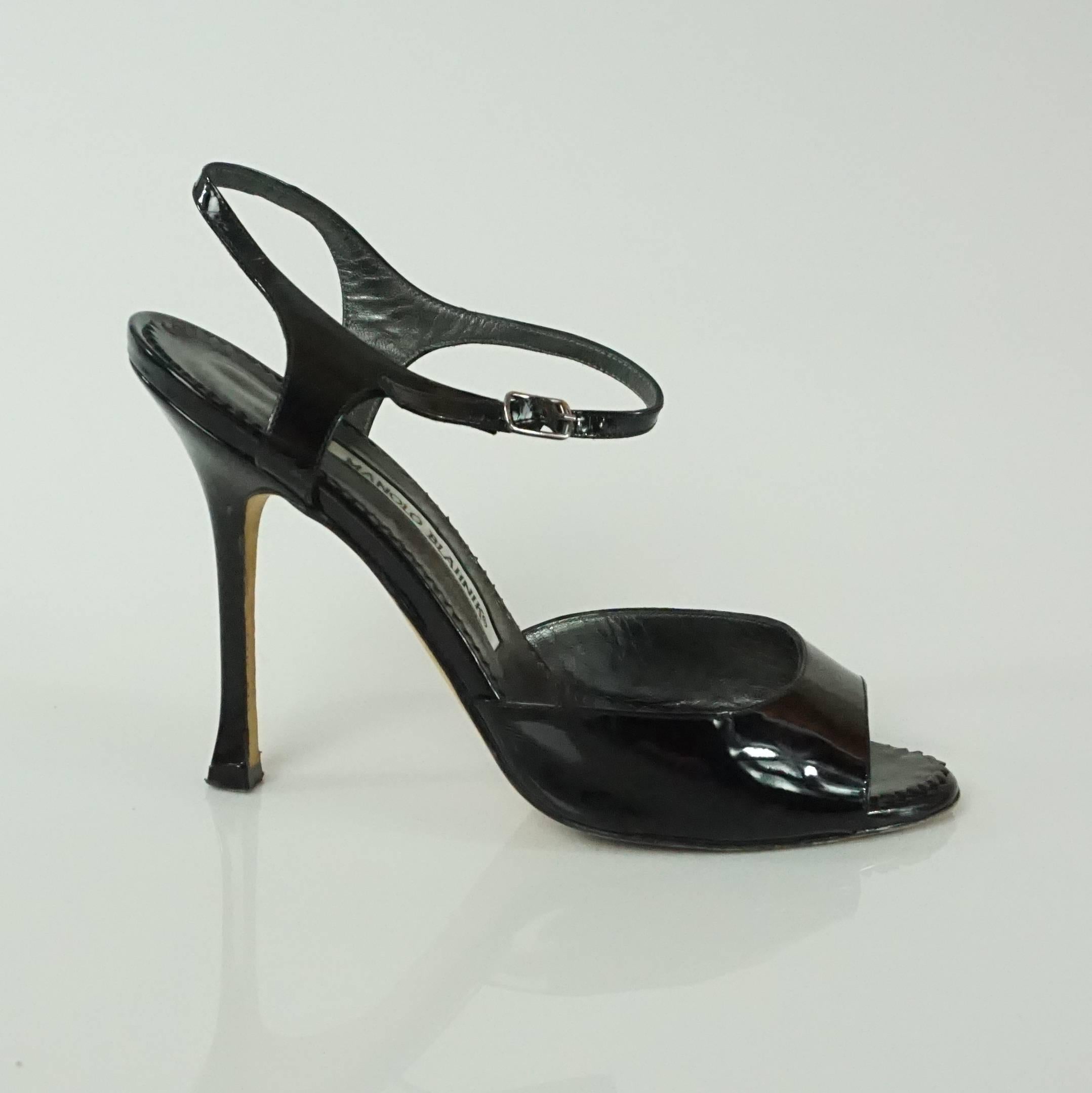 These Manolo Blahnik open toe black heels have an ankle strap and a silver buckle on the strap. A duster is included. They are in excellent condition with some bottom wear.

Measurements
Platform: 0.25