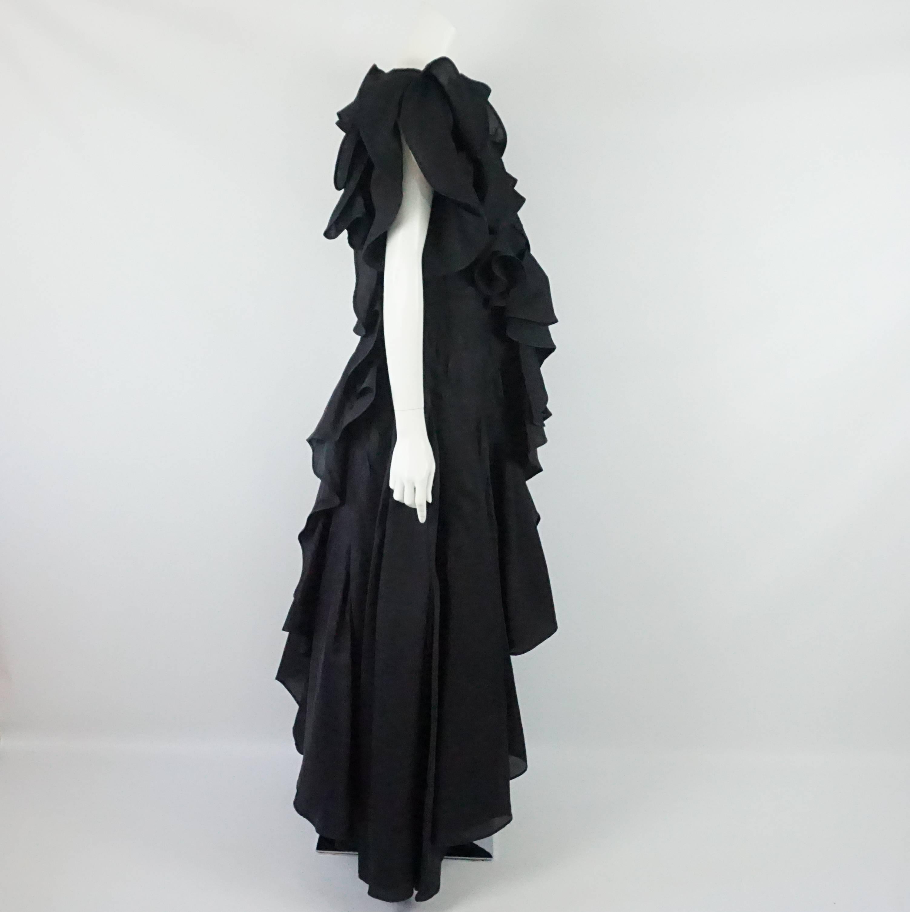 This Akira long coat is sleeveless and has large ruffles. The coat has an open and flowing structure. The front and back have a cascading form. It is in excellent condition. Size 8, circa 1980's. 

Measurements
Bust: 36