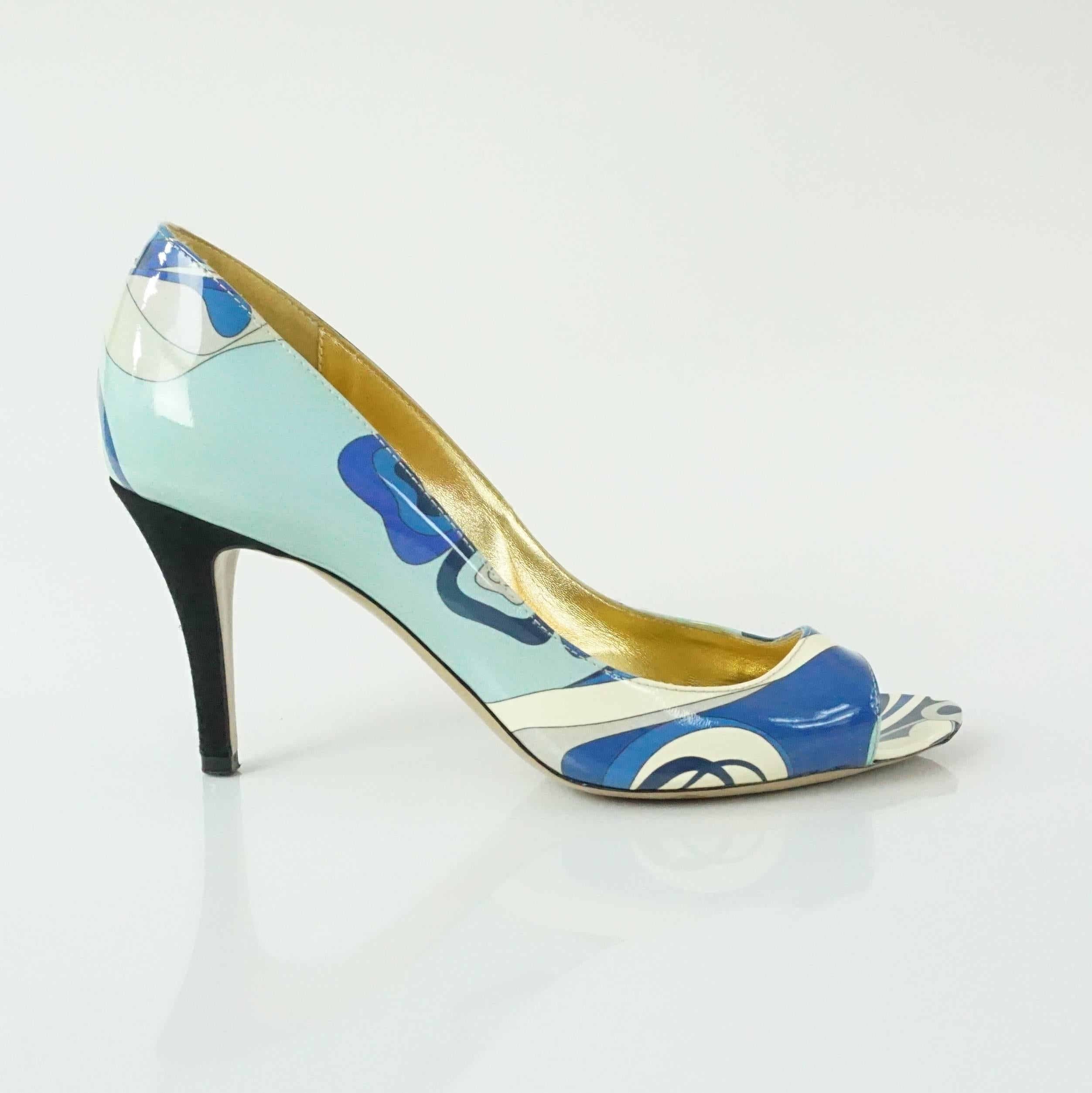 These Emilio Pucci heels are blue patterned patent leather. They have a peeptoe and a black heel. A duster is included. These shoes are in good condition with some markings and some raw strings.

Measurements
Heel: about 3.25