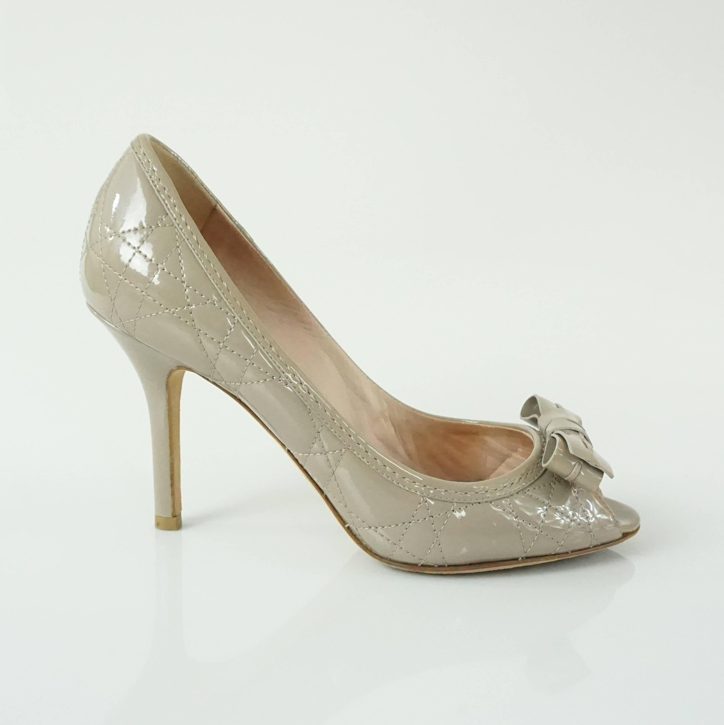 These Christian Dior quilted patent heels have a peep toe. They are taupe and have a bow by the toe. They come with a duster and are in very good condition with some wear on the bottom and some very minor wear on the leather.

Measurement
Heel: