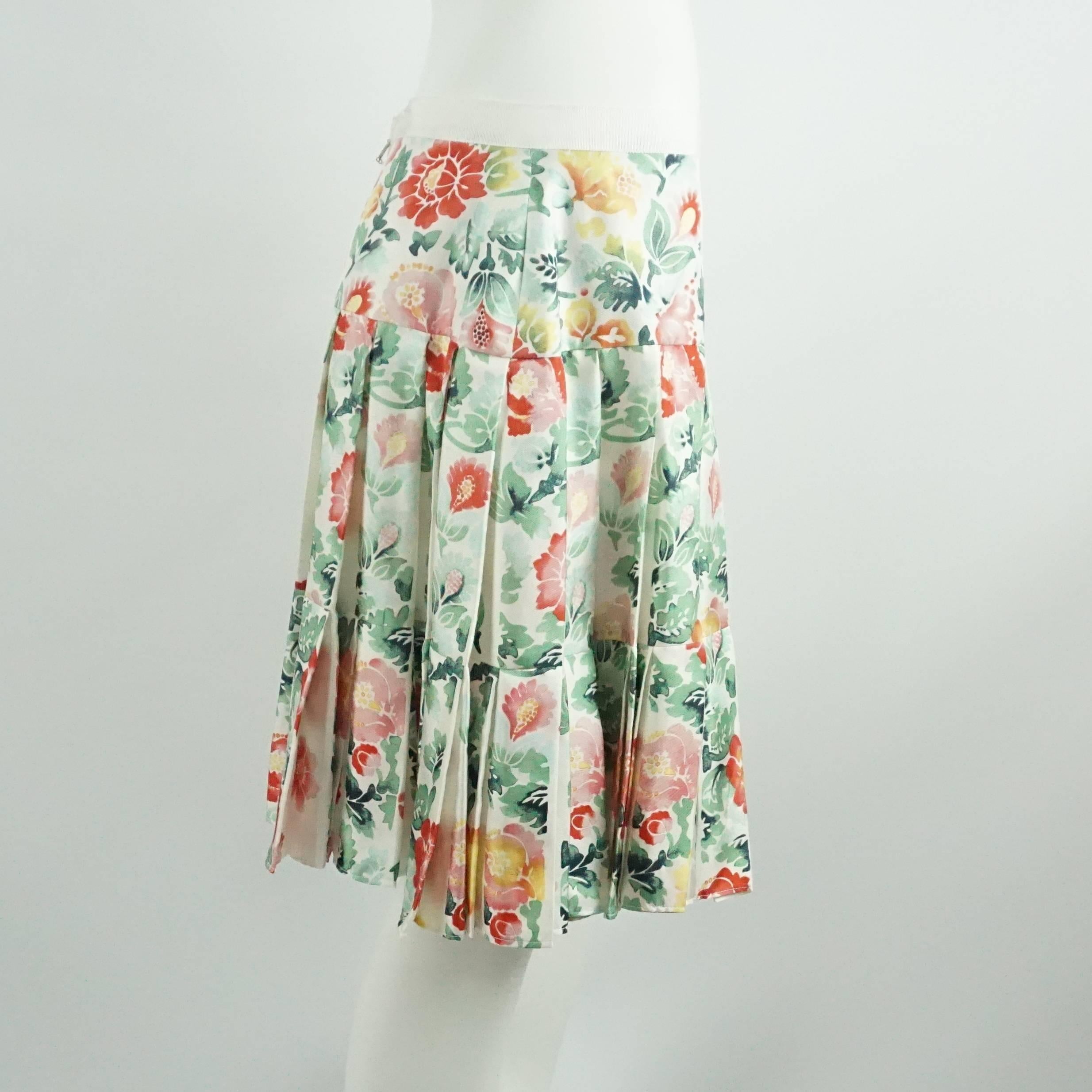 This Oscar de la Renta is white silk. This skirt has a multicolored floral design with colors such as green, red, and pink. This skirt also has pleats. It is in excellent condition.

Measurements
Waist: 32