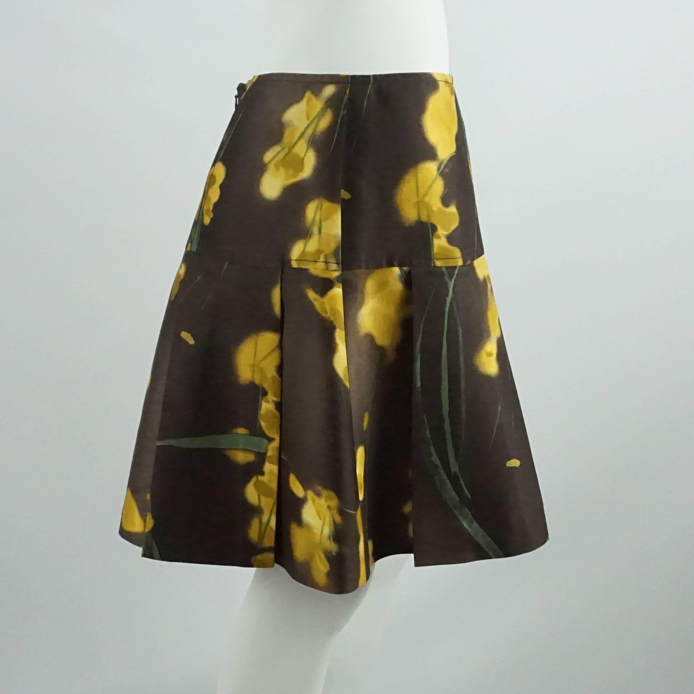 This Oscar de la Renta skirt is brown silk and has some pleating. It has a floral design of yellow and green. This skirt is in excellent condition.

Measurements
Waist: 32