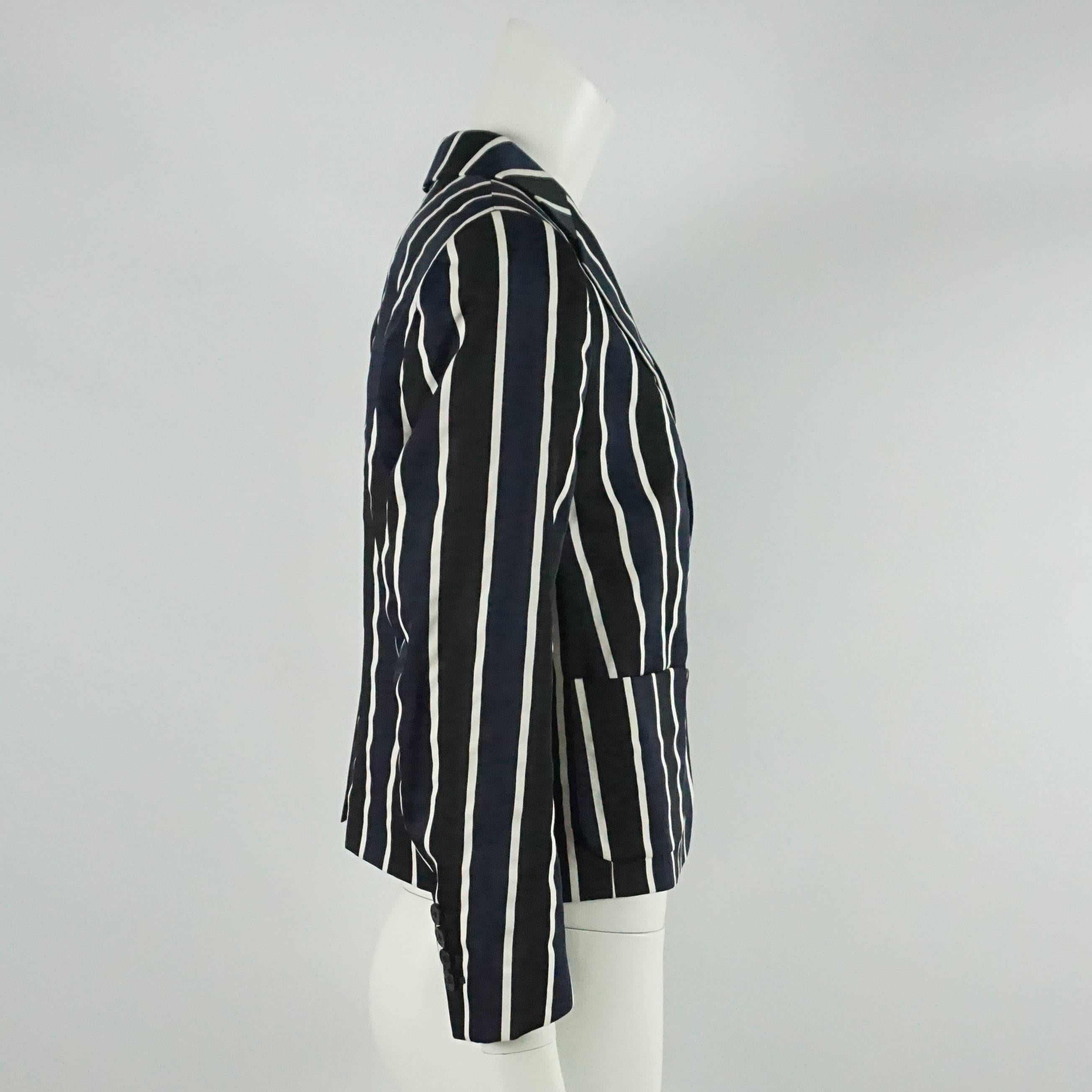 This beautiful Dries Van Noten silk jacket has black, navy, and white stripes. This jacket has front buttons and pockets. This jacket is in very good condition with some very minor wear.

Measurements
Shoulder to Shoulder: 15.25