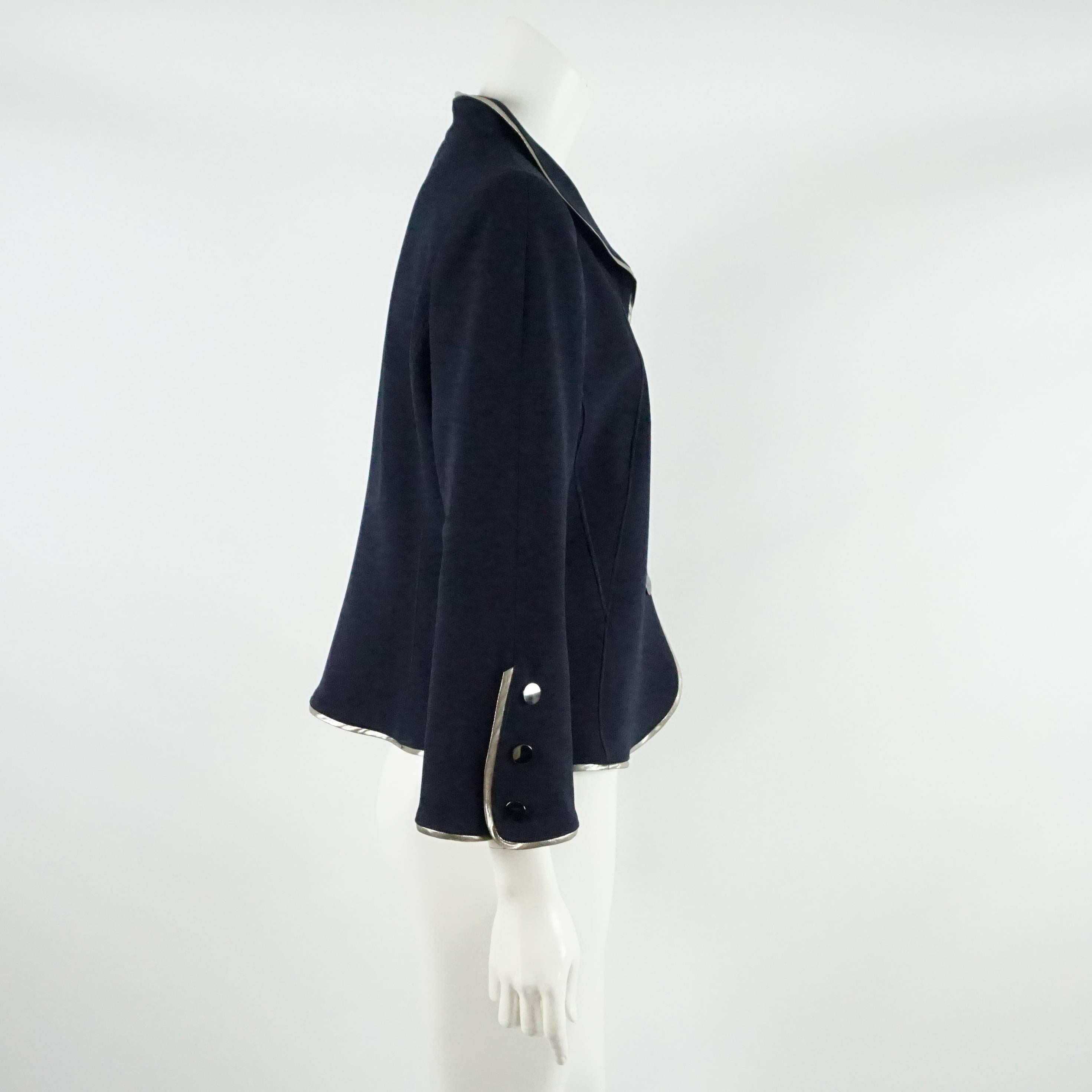 This beautiful Oscar de la Renta jacket is made of navy wool. It has a silver trim and three snap buttons going down the front. This jacket is in excellent condition.

Measurements
Shoulder to Shoulder: 16.5