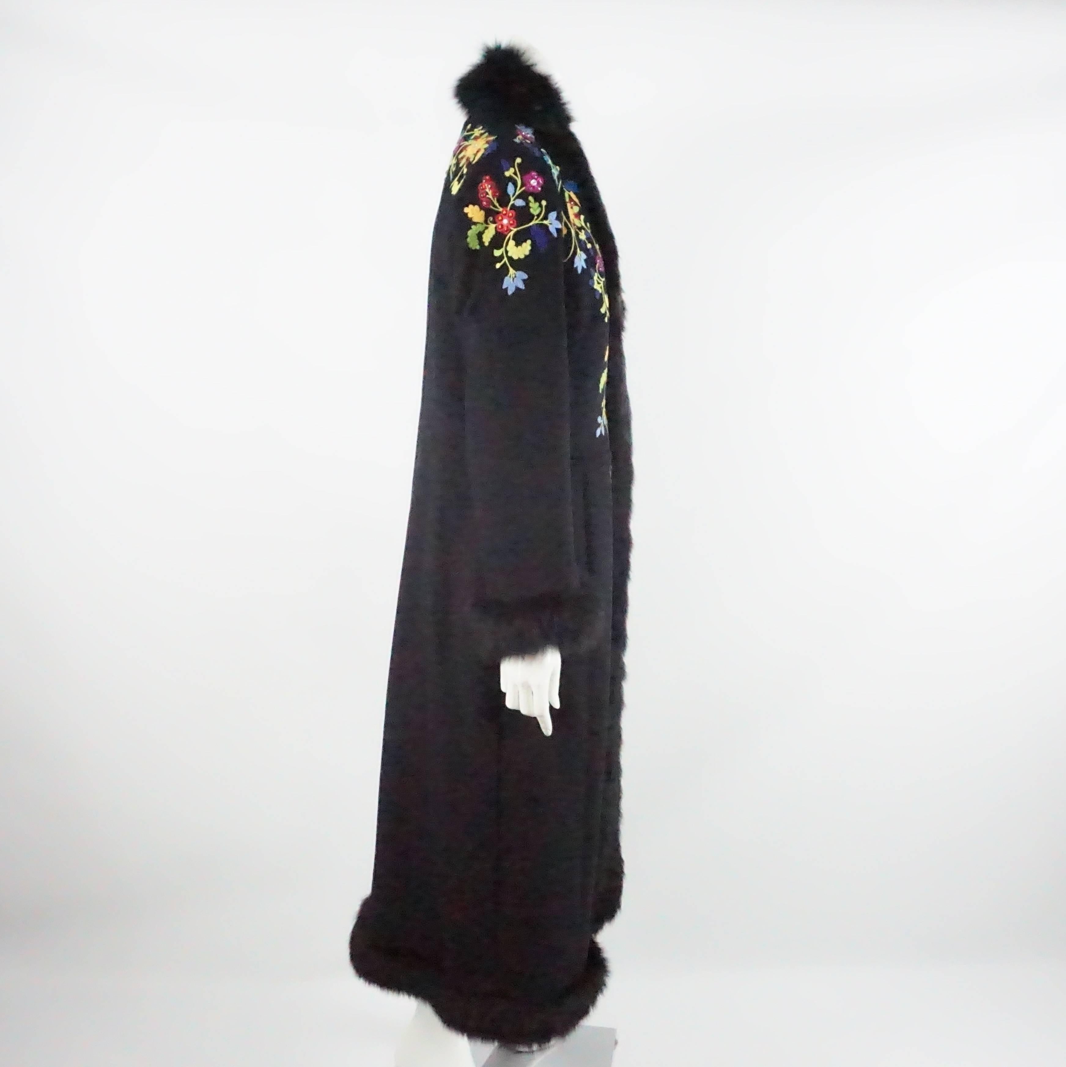 This Escada black coat is made of angora and virgin wool with a fox fur trim. It also has multi colored embroidery with colored rhinestones. The coat is floor length with side pockets and light shoulder pads. It closes with hook and eye closures