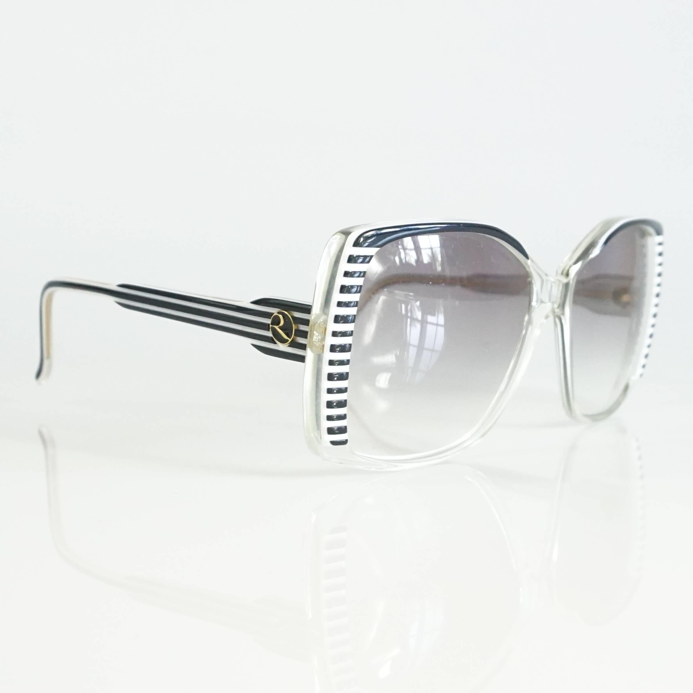 These fun and vintage handmade Rochas sunglasses have large square frames. They are made of black and white Lucite. They are in excellent condition. Circa 1970's.

Measurements
Leg Length: 4.75"
Front (lens to lens): 5.75"
Lens