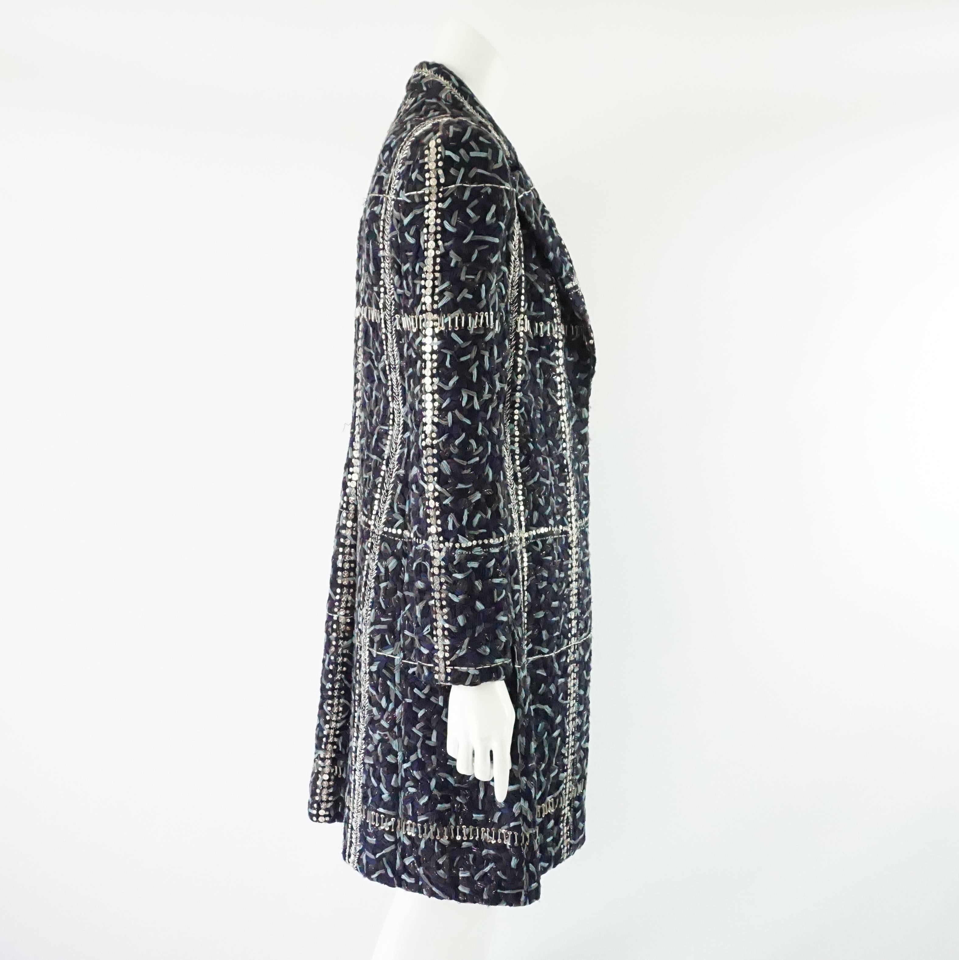 This beautiful Bill Blass wool coat is textured and has beads and sequins making a checkered pattern. The fabric is a mixture of light blue, dark blue, purple, gray, and black. This coat is in excellent vintage condition with some loose beads and