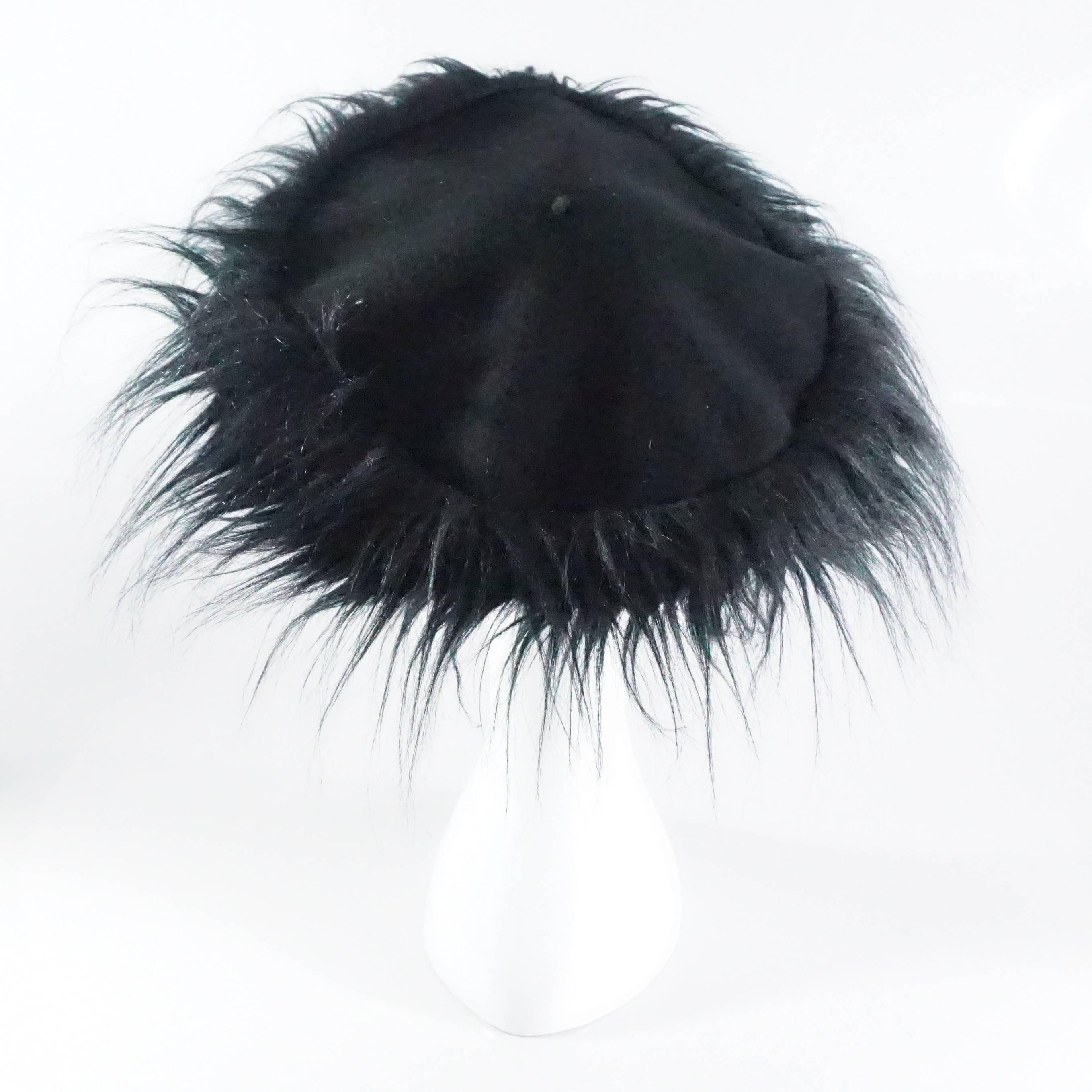 This Chanel beret is made of black wool with a faux fur trim. It is a size 56.This beret is in excellent condition with light wear to the wool. 

Measurements
Hat: 11.25” x 12”
Trim: 4.5”
Circumference: 18.5” – 22.5” 
