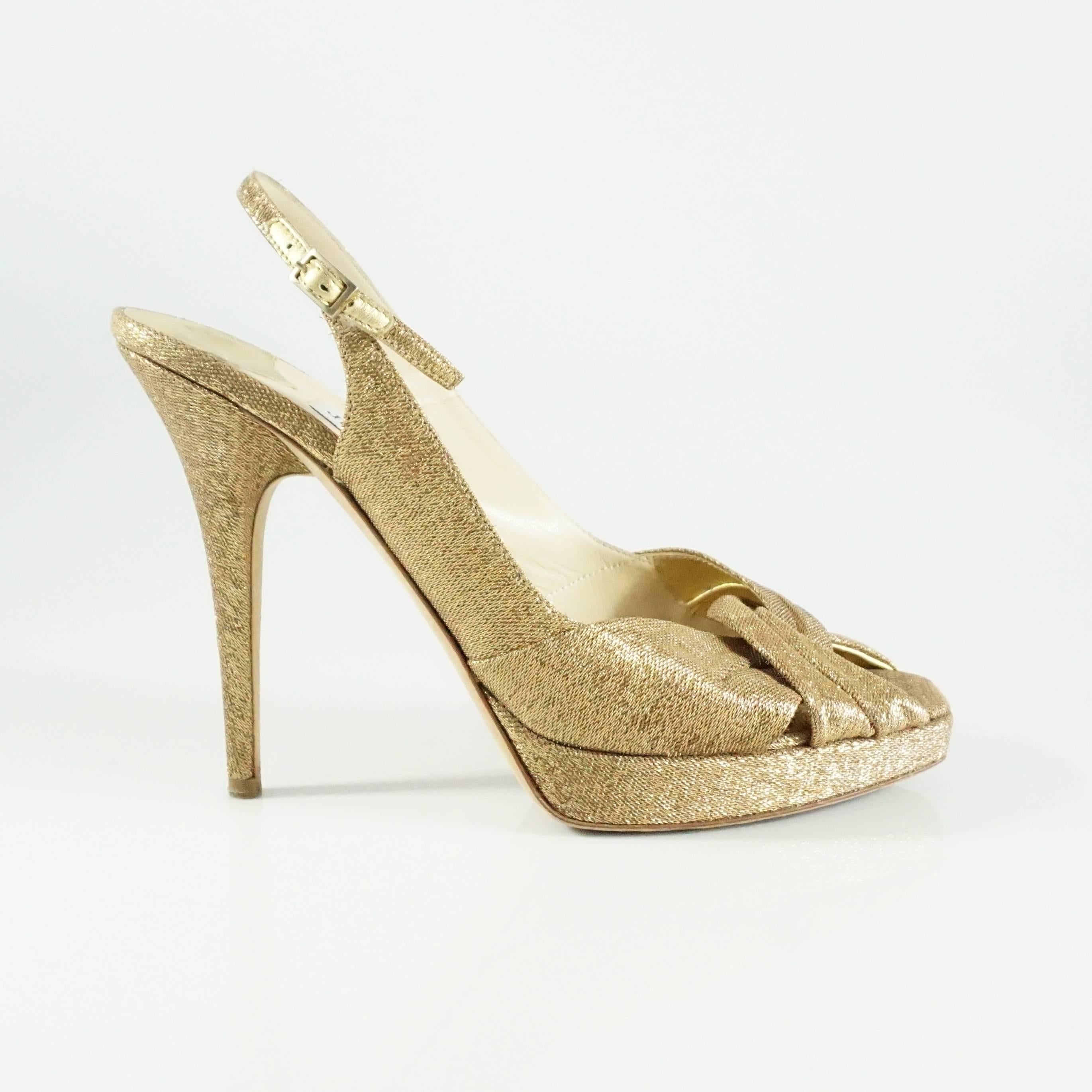 These beautiful Jimmy Choo slingbacks are made of shimmery gold fabric. They have a slingback with a clasp and an open toe. The toe bed is angular. These shows are in excellent condition with bottom wear.

Measurements
Platform: 1