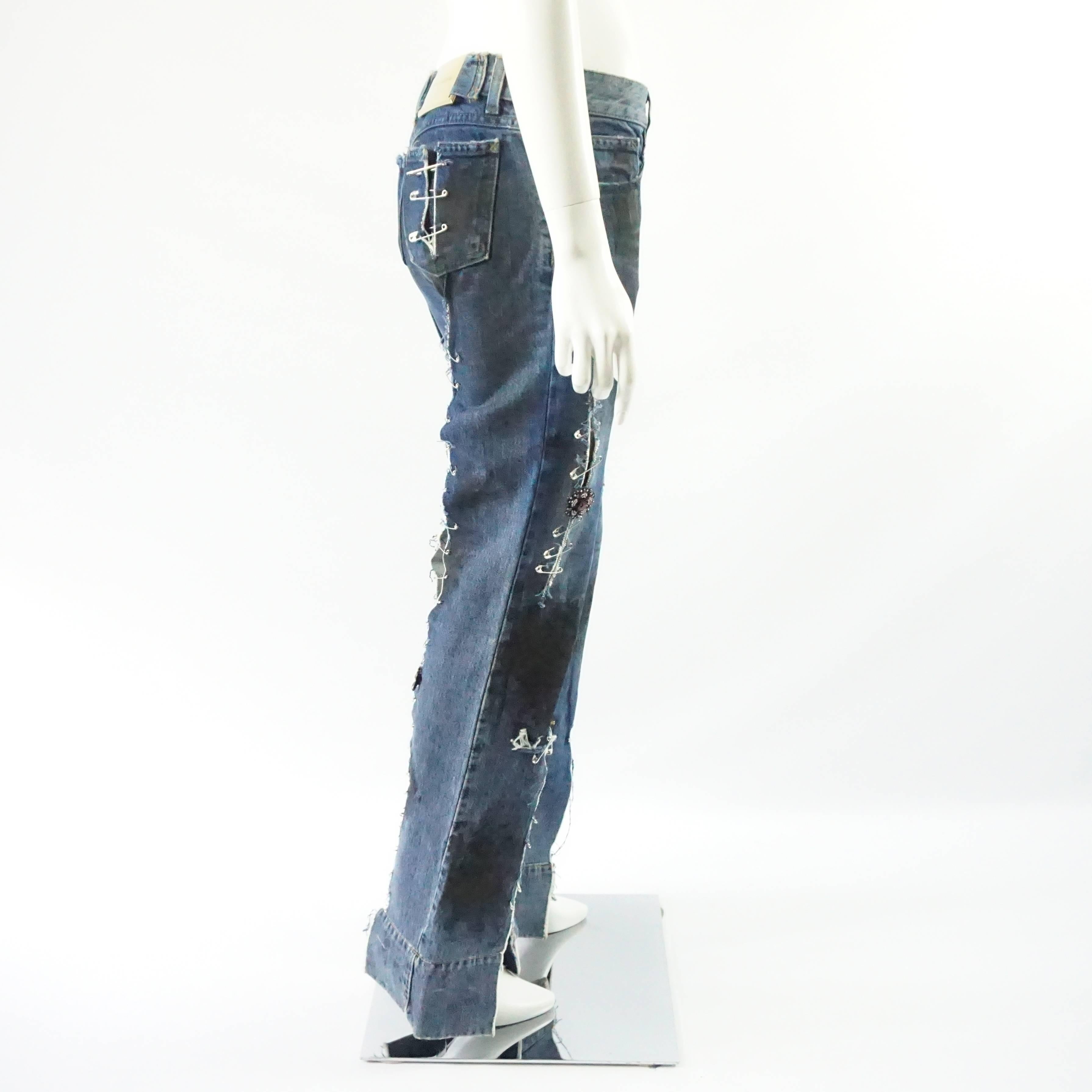 These very unique Dolce & Gabbana grunge jeans have a flared leg and are highly distressed. They have black splashes all over and slits on the thighs, bottom of the leg, back pockets, and on the back of the legs. One of the splashes is in the shape