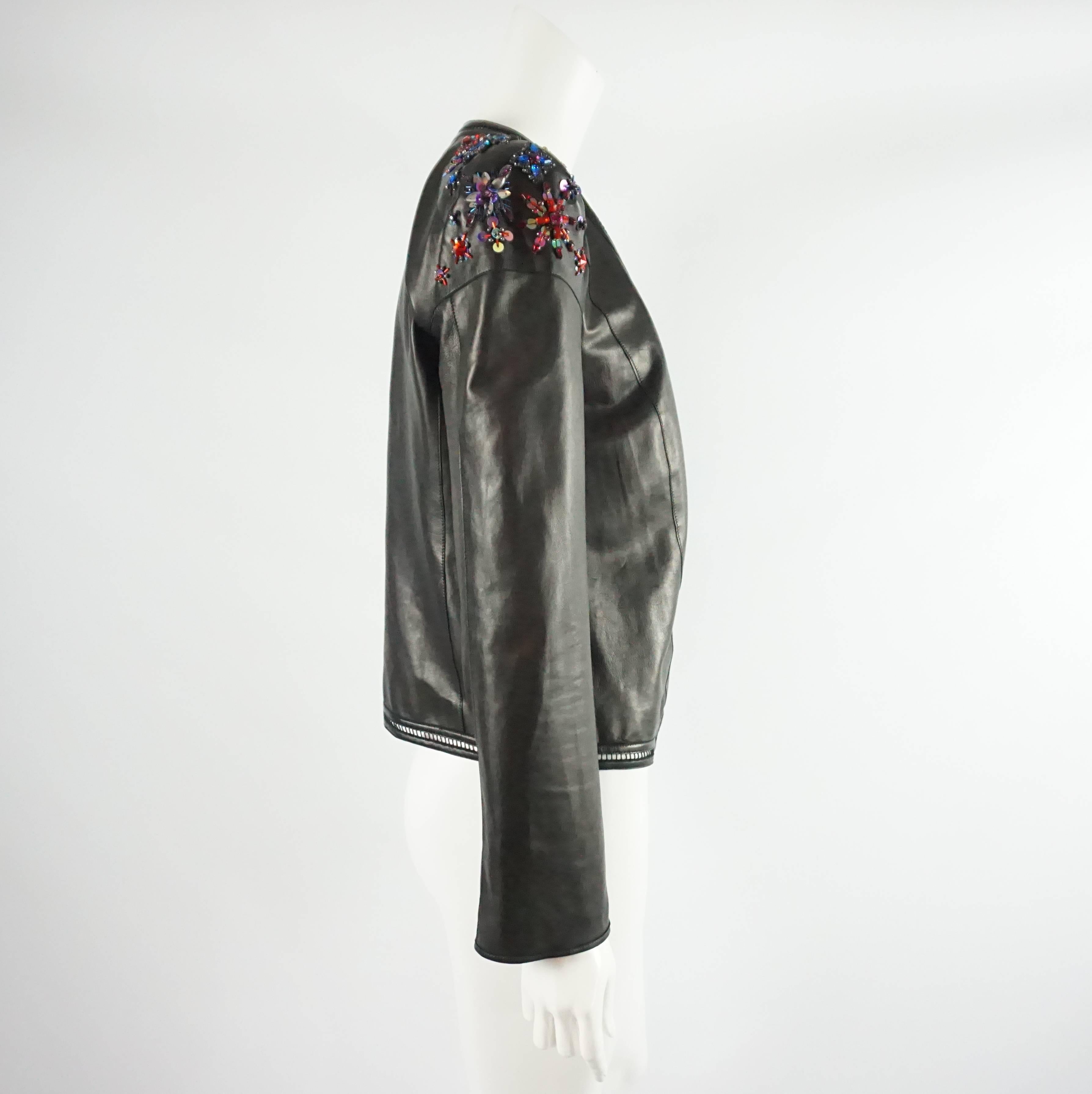 Roberto Cavalli black leather Stone/Bead/Paillette - Size 44. This jacket has one small closure in the front, is fully lined, has a perforated leather detail trim.  On both shoulders there are multi-colored rhinestone and sequin detailing. This