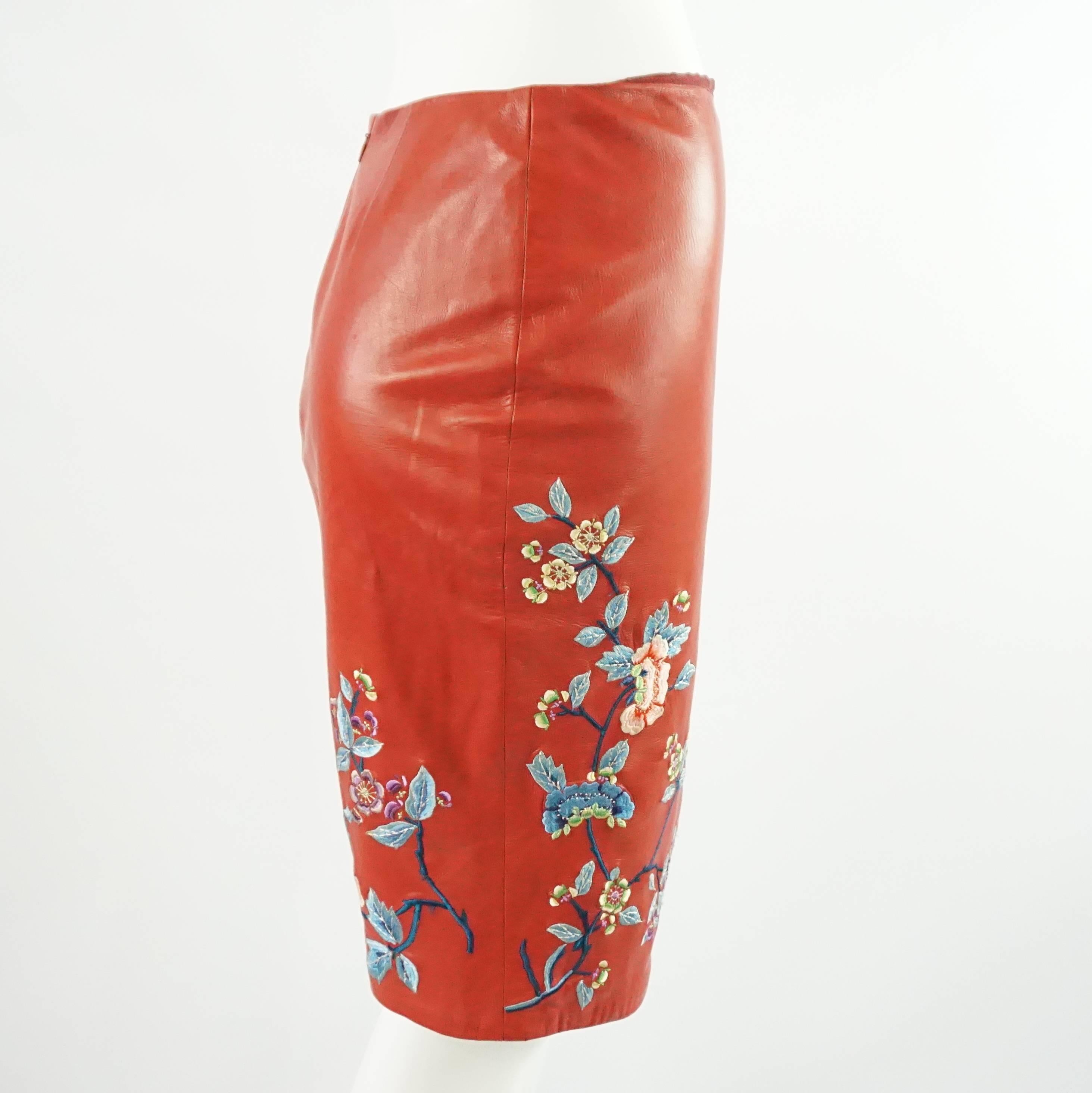 This Ralph Lauren skirt is red leather and has embroidery. The embroidery is a print print with multiple colors such as blue, yellow, and pink. There is a side slit. This skirt is in very good condition with some markings.

Measurements
Waist: