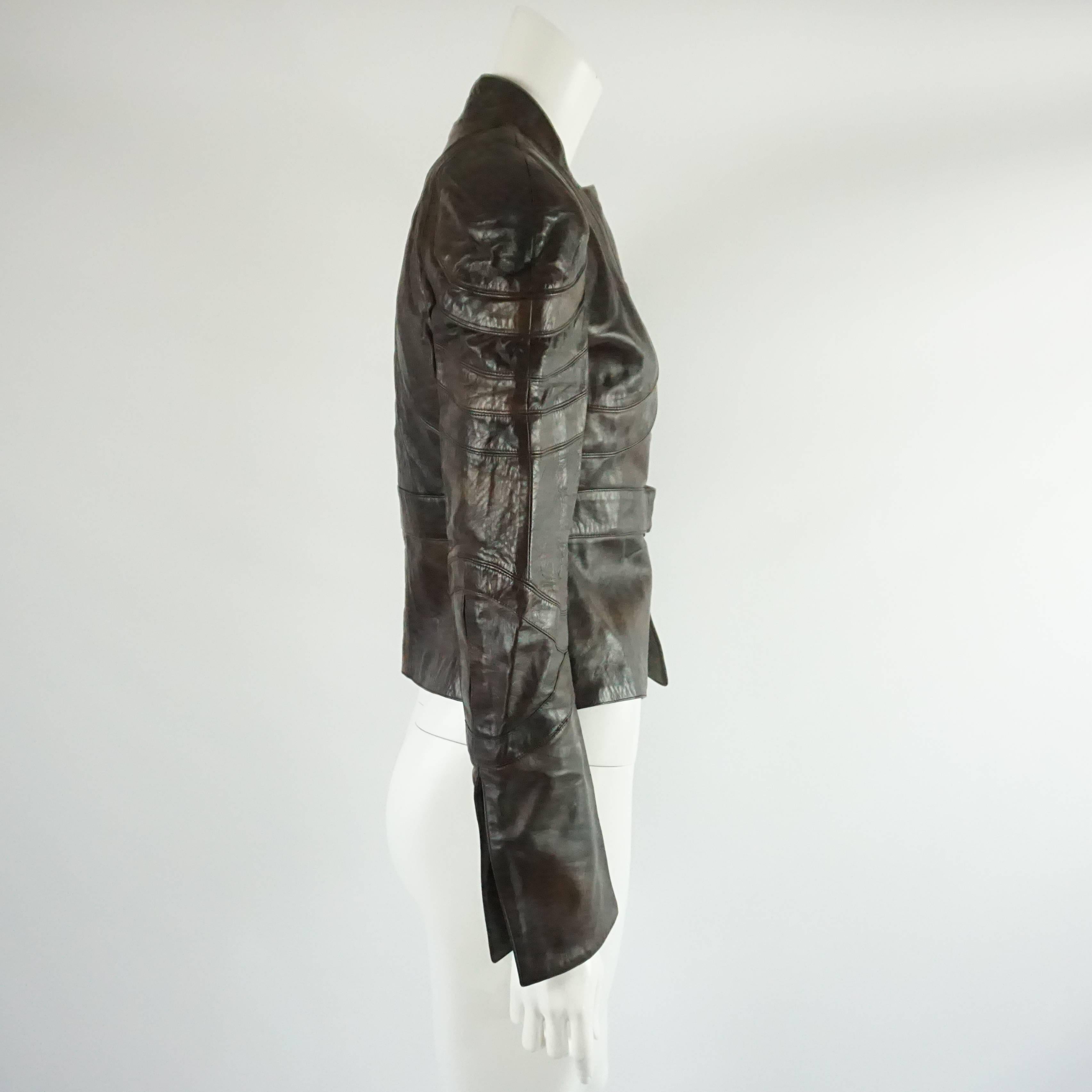 This fabulous Valentino leather jacket is tapered at the waist and has a button on the waist band. It is both chocolate brown and a lighter brown. The cuffs have a slit in them. This jacket is in very good condition with some discoloration and