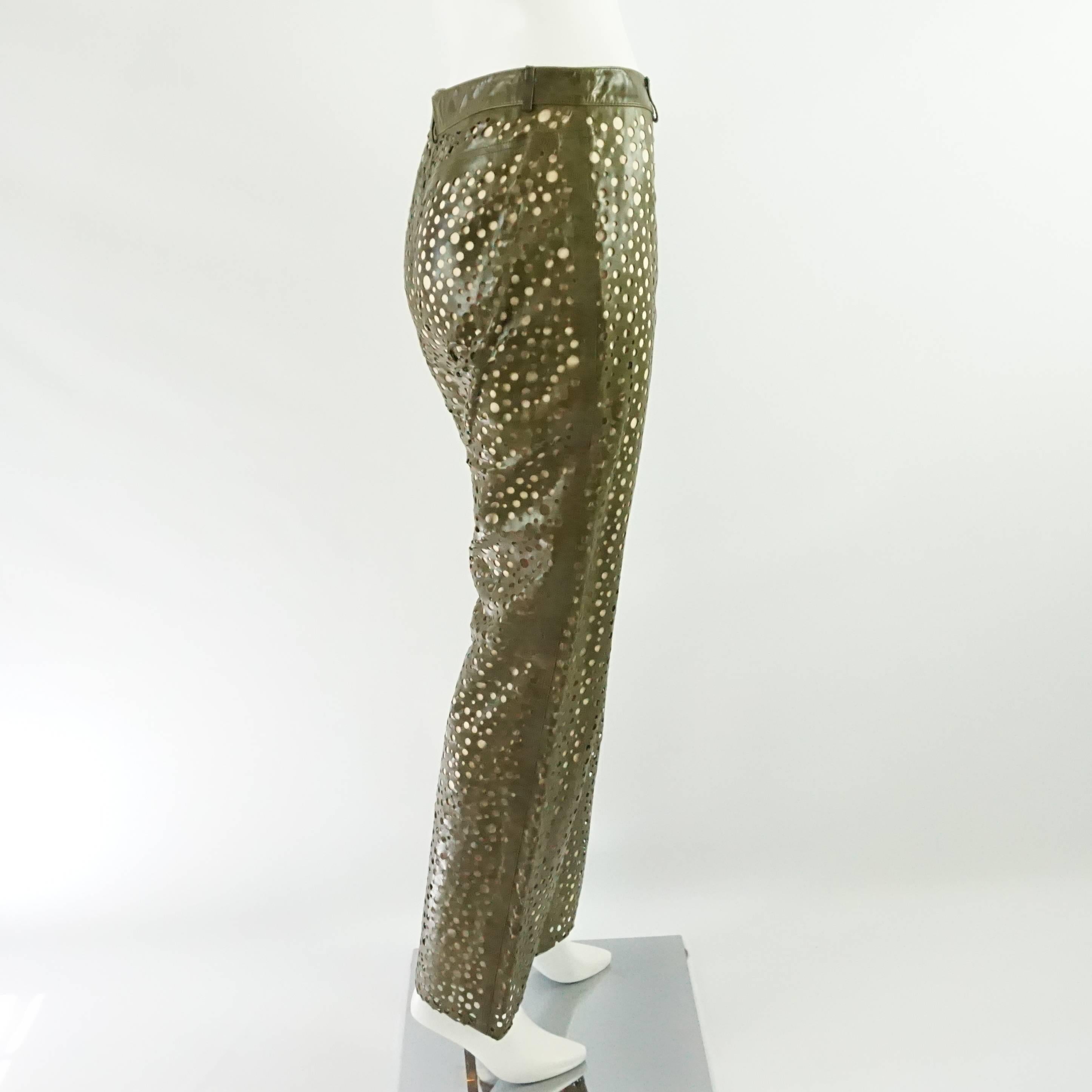 These YSL Rive Gauche pants are made of perforated olive leather with a beige lining. They are high-waisted with a slight flare and back pockets. They are a fabulous, unique piece and are in excellent condition with light leather wear. Size small,