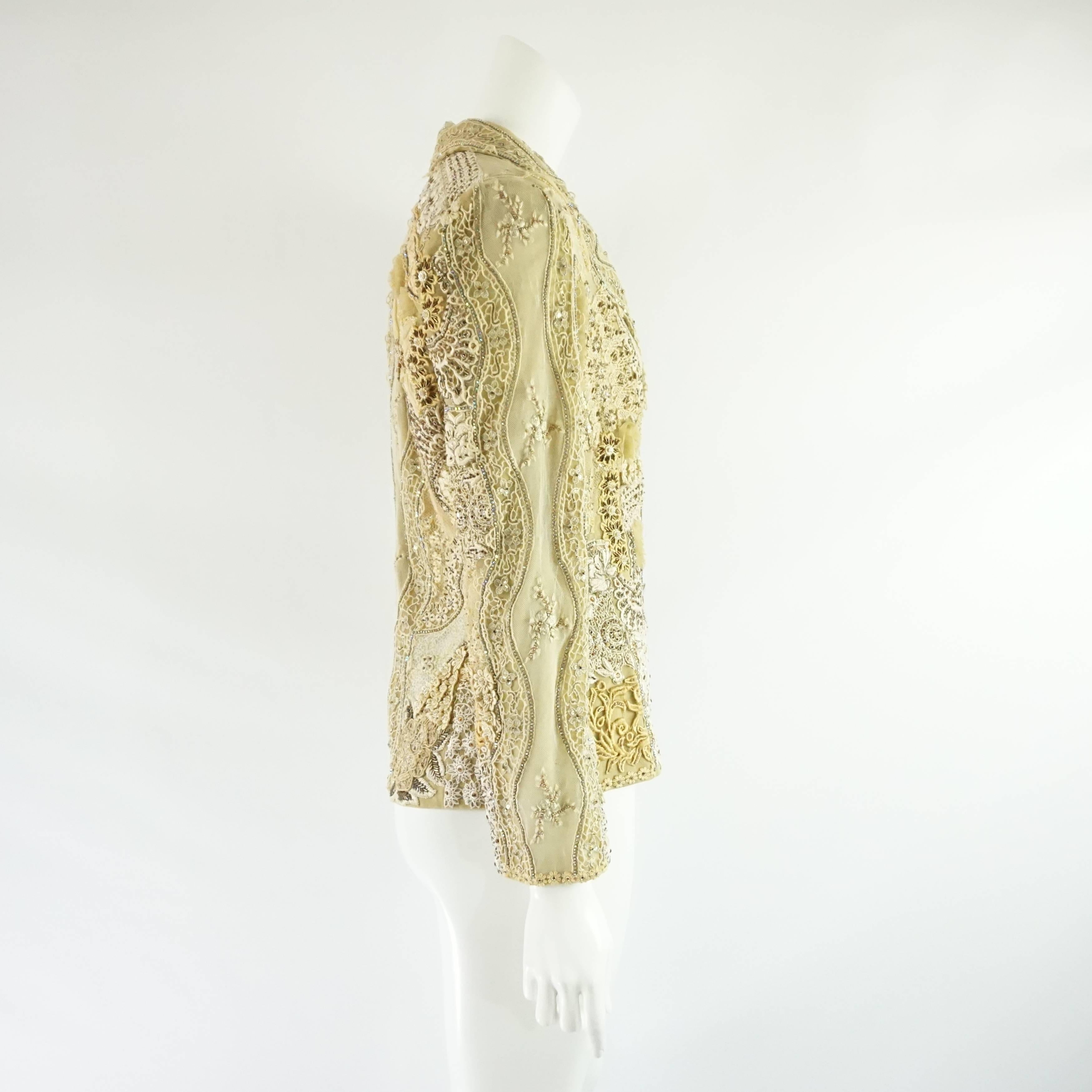 This stunning Ella Singh jacket is covered with different types of lace and embroidery with rhinestone strips and detailing. The jacket has a collar, shoulder pads, and iridescent buttons. The piece is in good vintage condition with some snags and