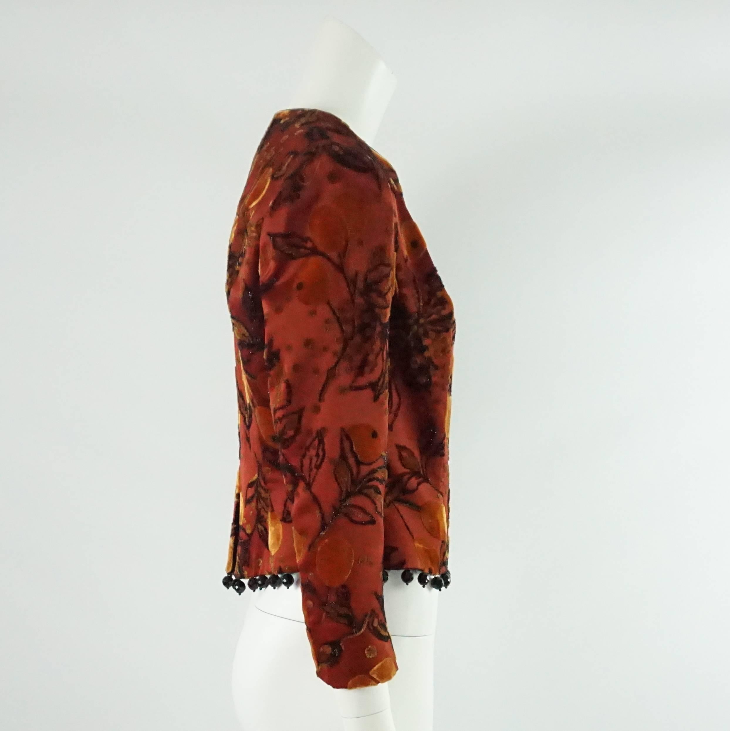 This Joanna Mastroianni jacket is red cut velvet with black hanging beads. It has orange, dark beige, and shimmery black on it. This jacket is in excellent condition.

Measurements
Shoulder to Shoulder: 15"
Sleeve Length: 21.25"
Bust:
